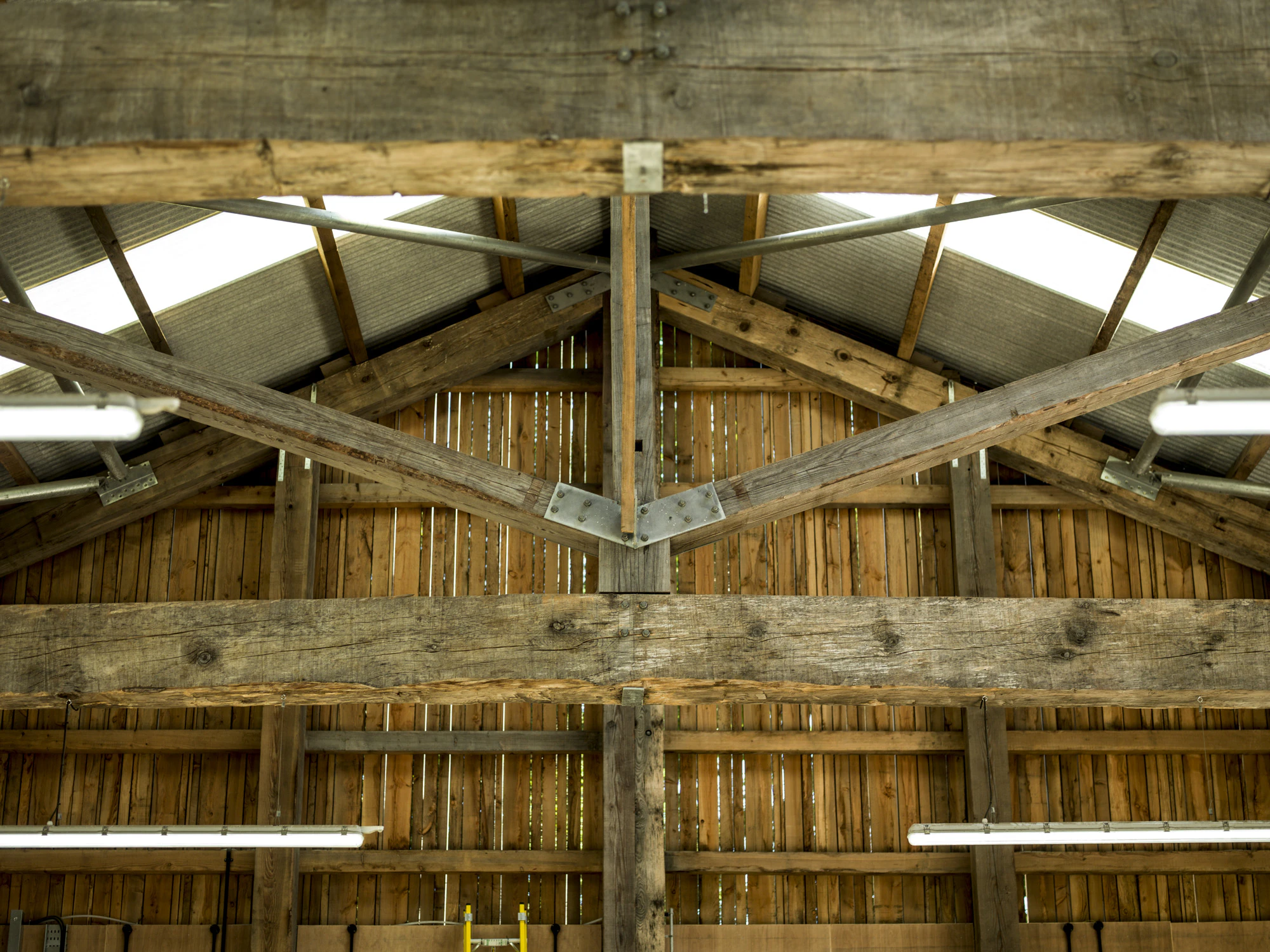 Close-up detail of a Douglas fir-framed truss inside a tractor shed