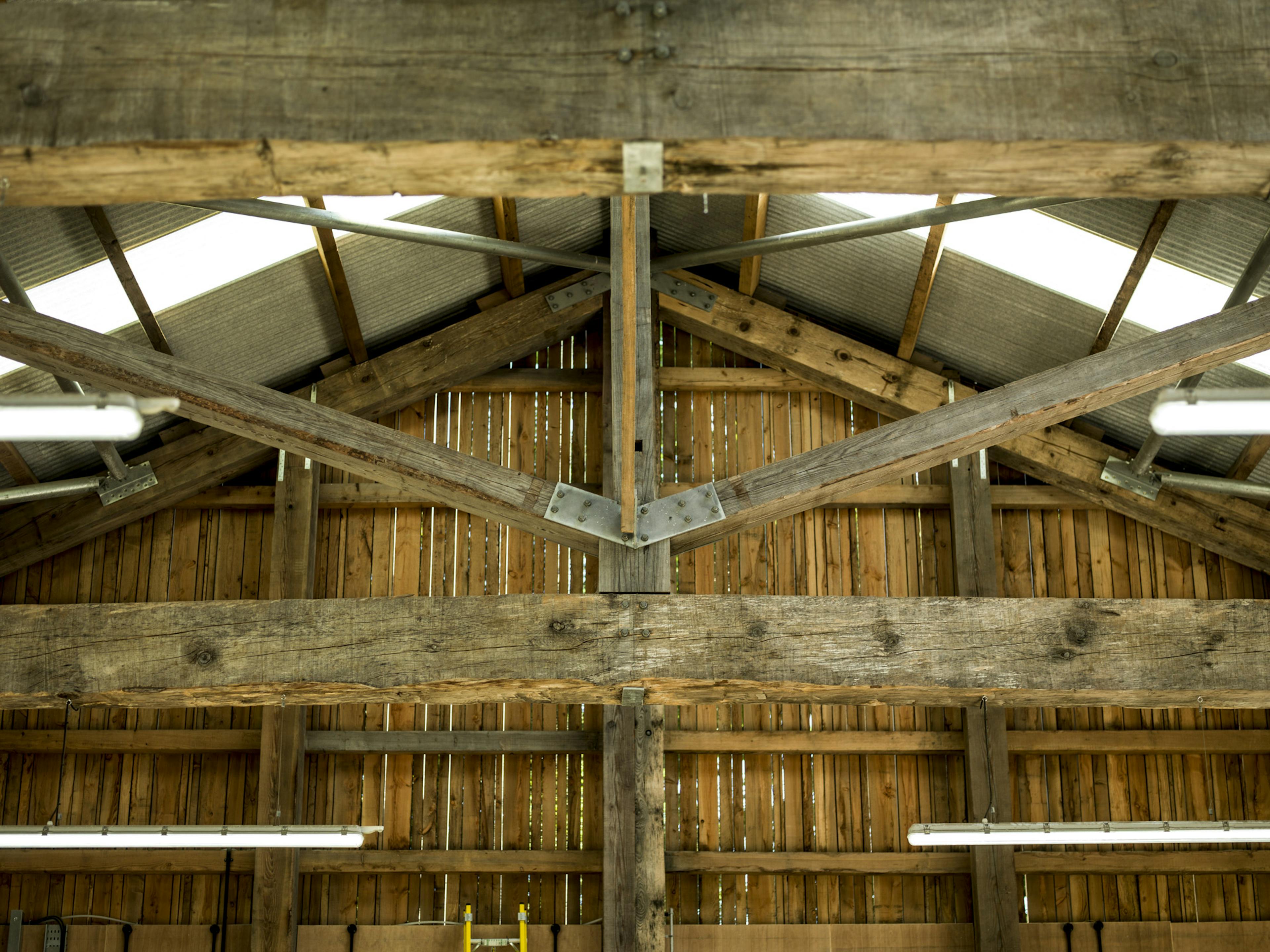 Close-up detail of a Douglas fir-framed truss inside a tractor shed