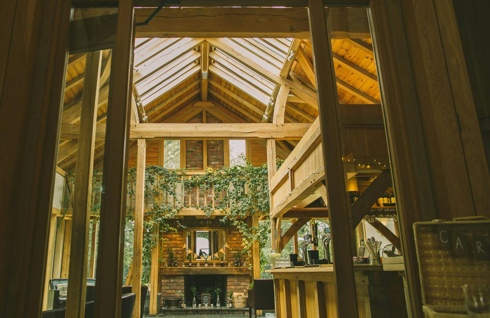 Rustic oak-framed wedding barn with vaulted ceilings and roof lanterns, allowing natural light to flood the interior