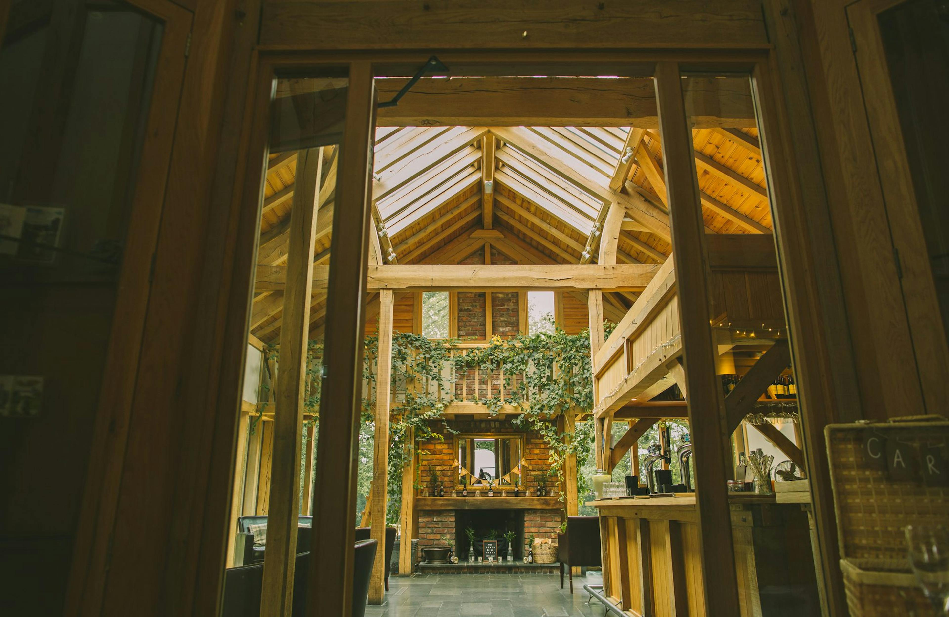 Rustic oak-framed wedding barn with vaulted ceilings and roof lanterns, allowing natural light to flood the interior