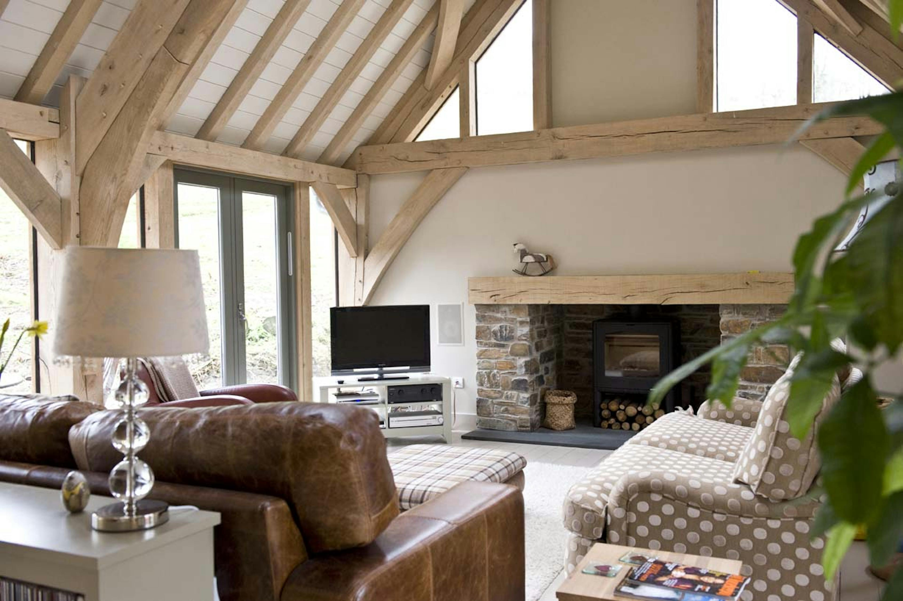 Interior view of an open-plan living space with vaulted ceilings and painted softwood paneling
