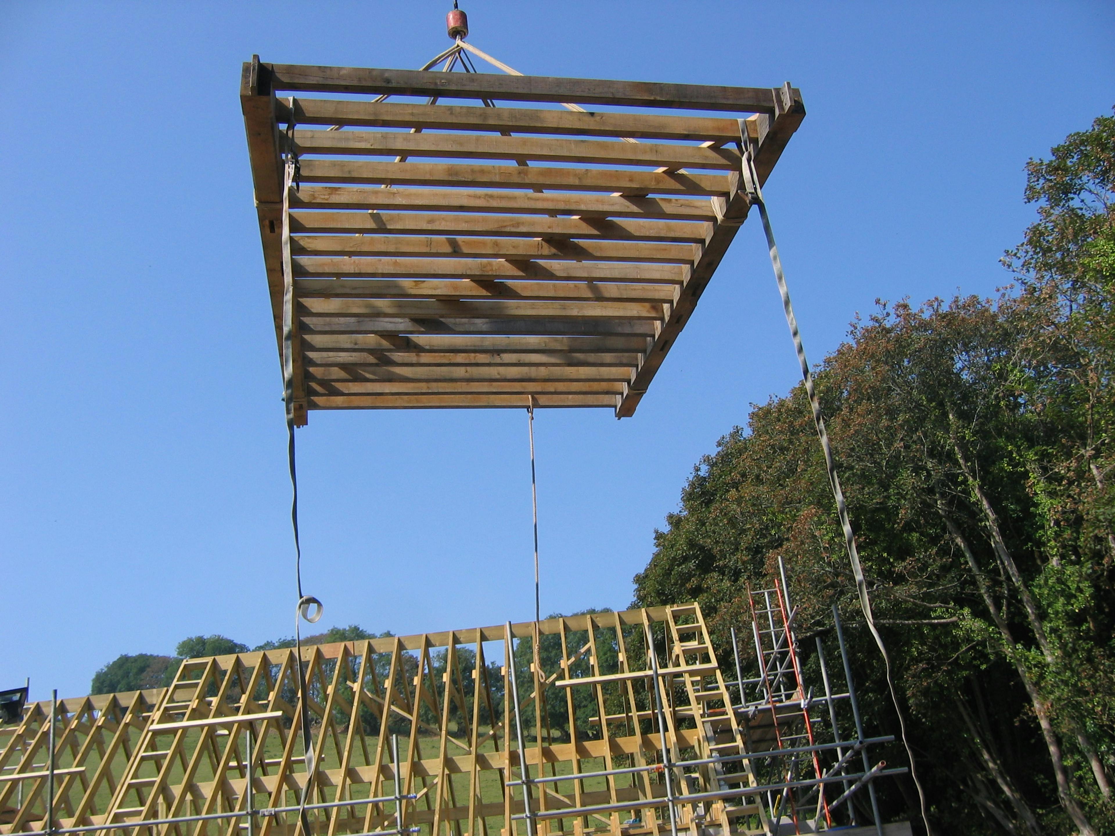 Lifting a pre-assembled oak floor section into place on-site