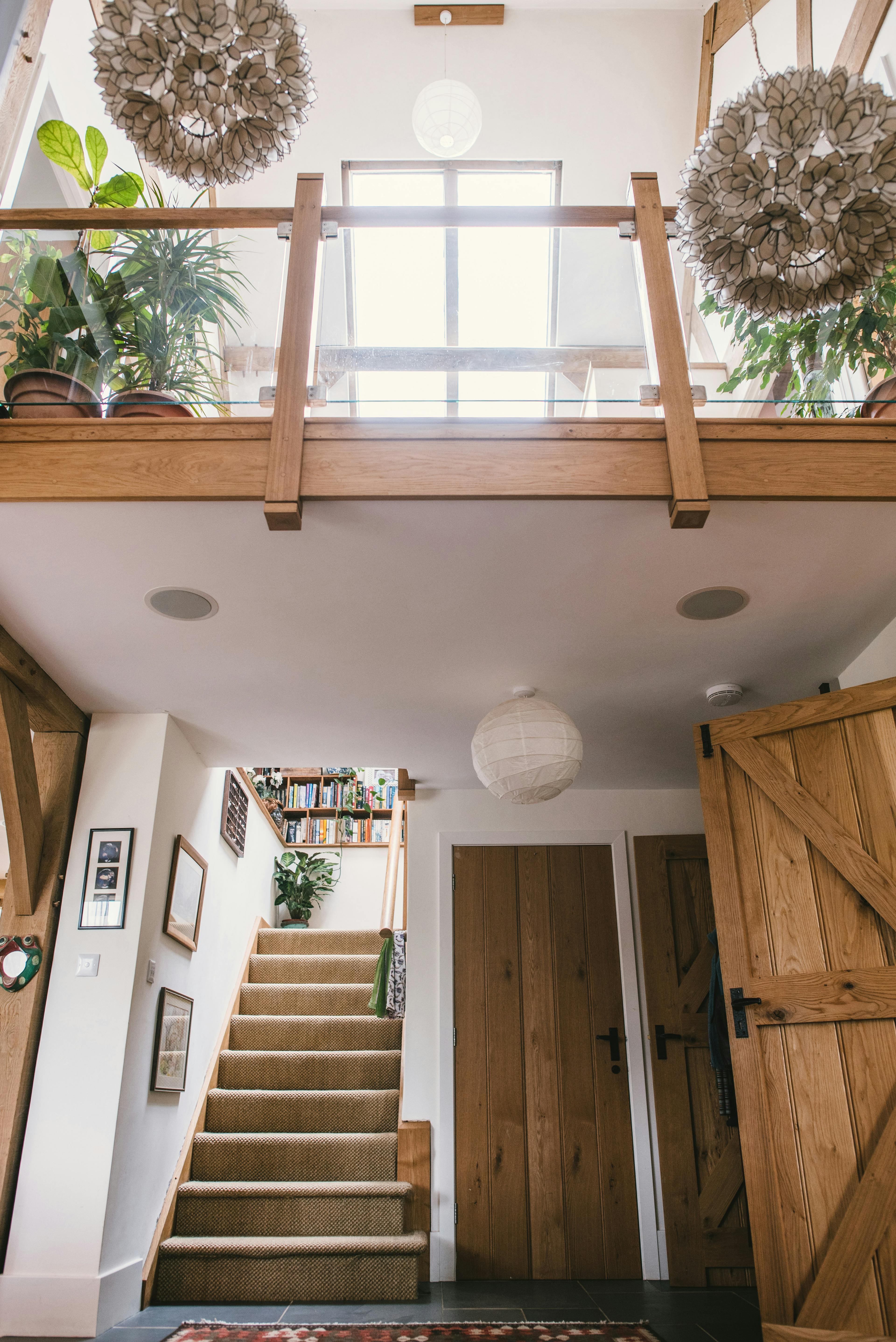 Interior view of a foyer in an oak-framed home, featuring vaulted ceilings and a glass mezzanine