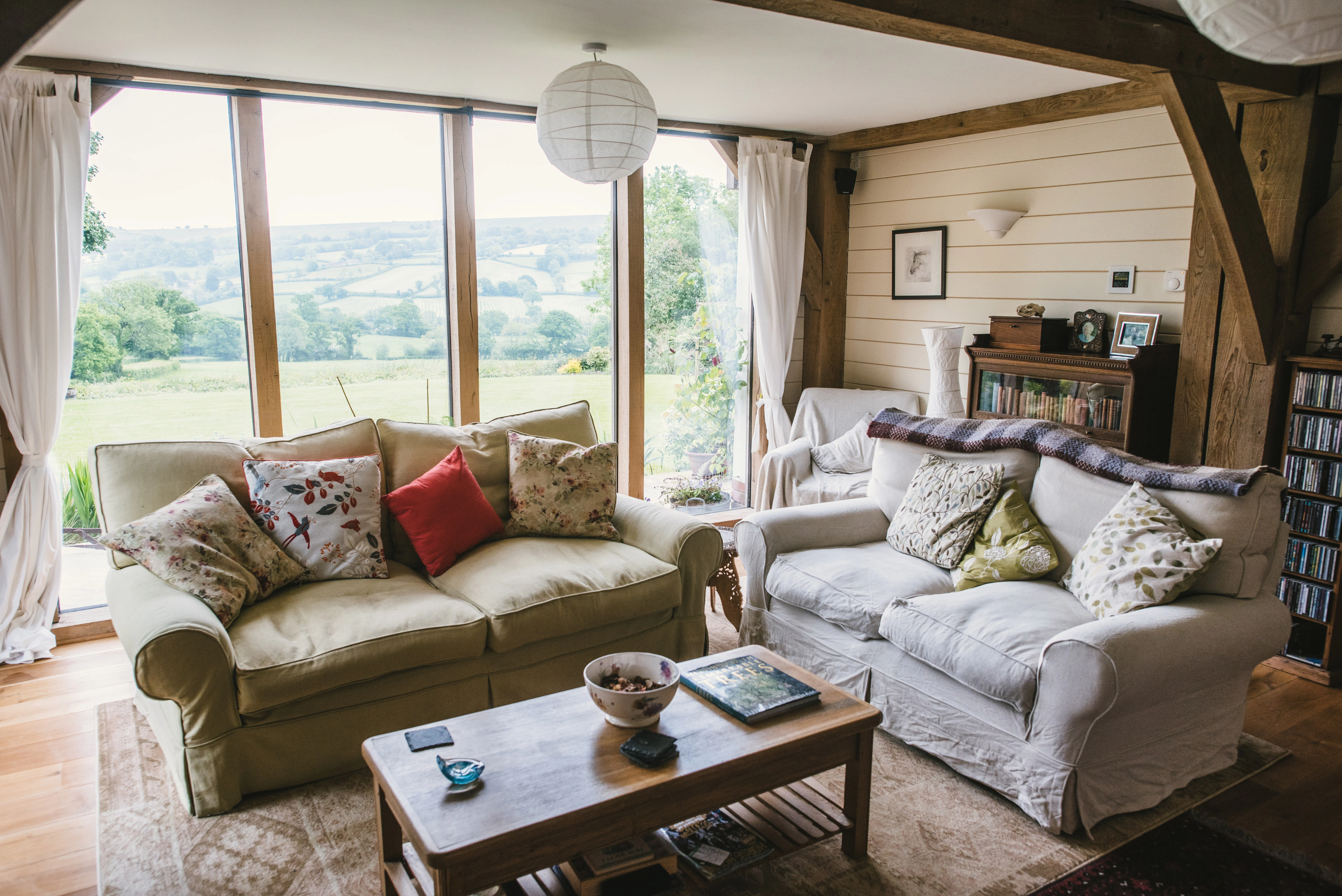 Interior view of a country-style lounge with oak-framed features and large windows overlooking the garden