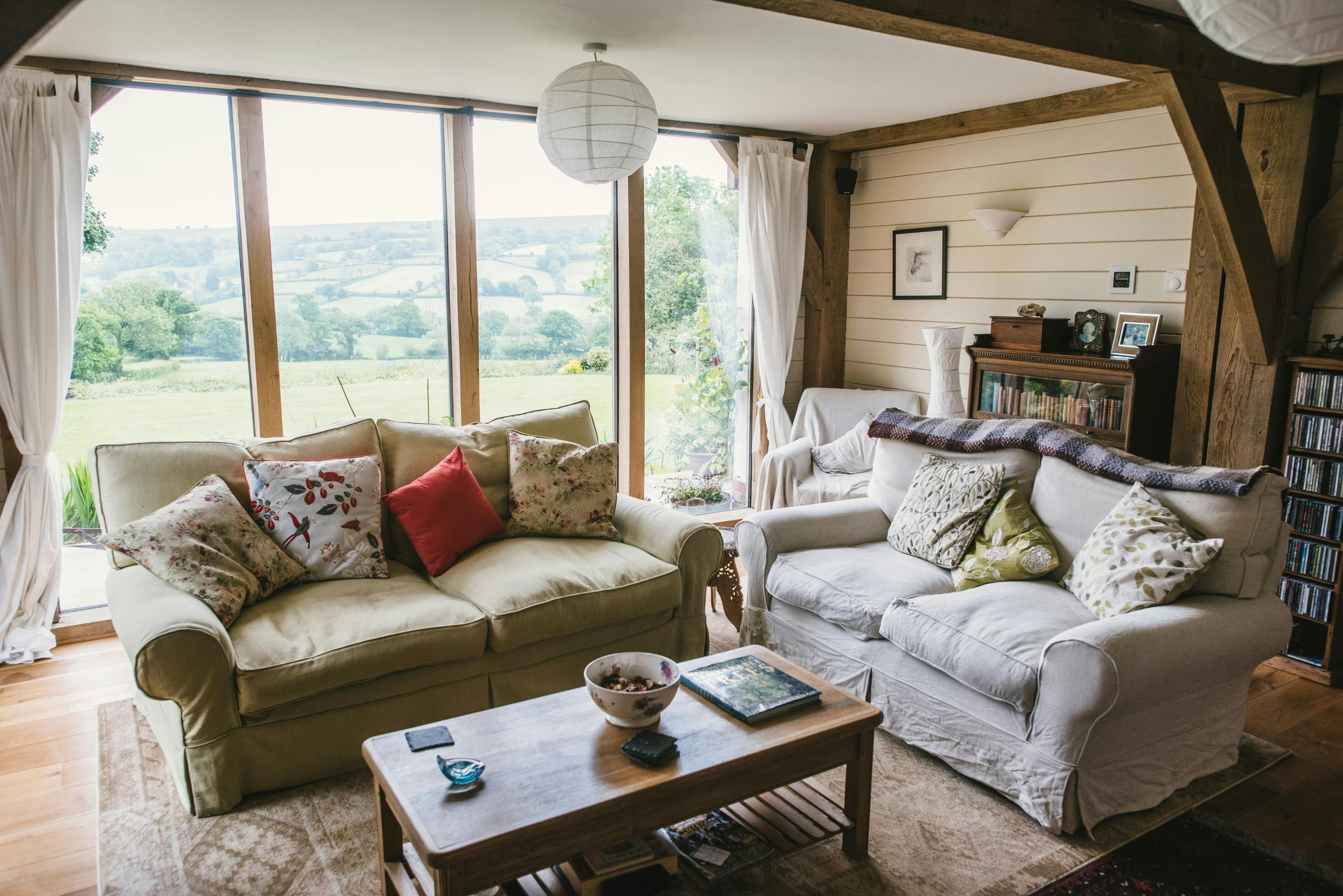 Interior view of a country-style lounge with oak-framed features and large windows overlooking the garden