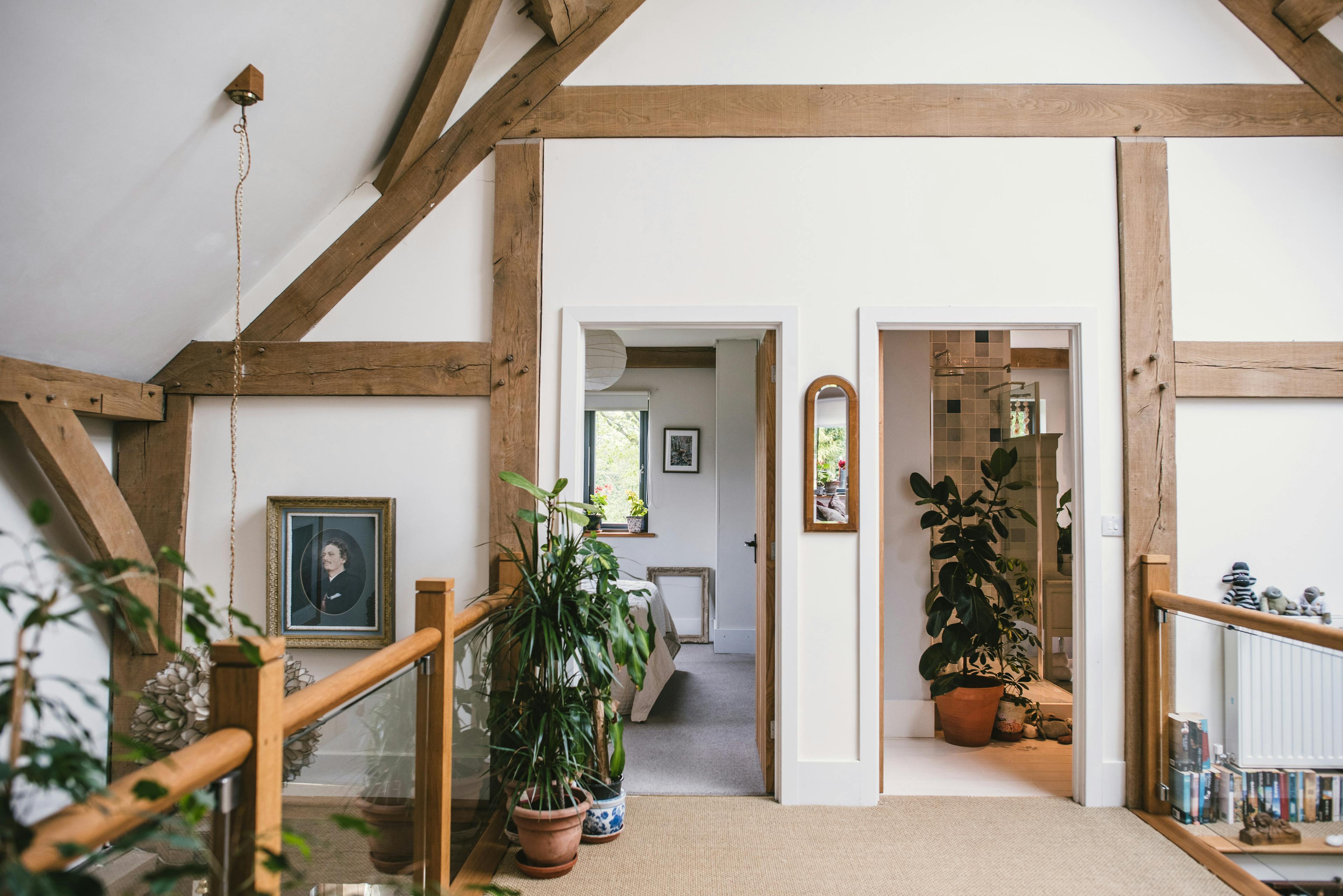 Interior view of an oak-framed family home featuring a glass mezzanine and vaulted ceilings