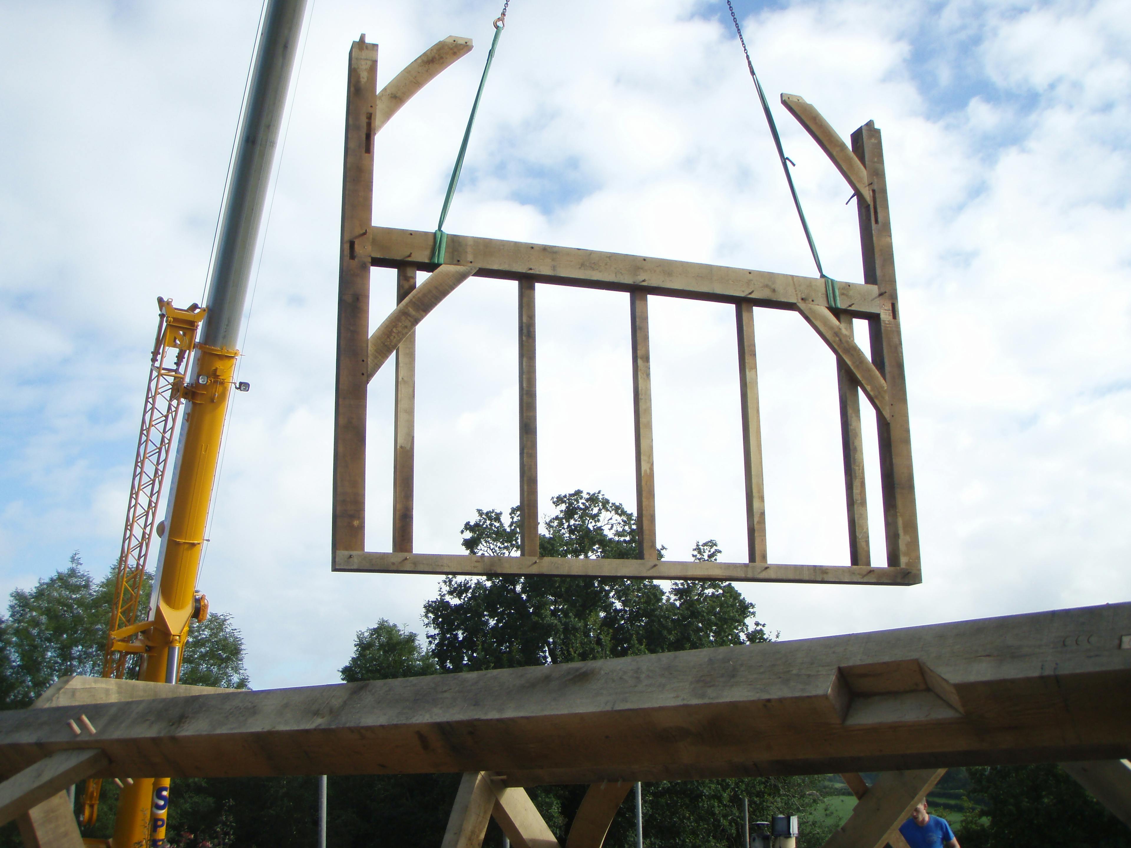 Lifting a large pre-assembled oak-framed section into place during the installation of a two-storey oak-framed home