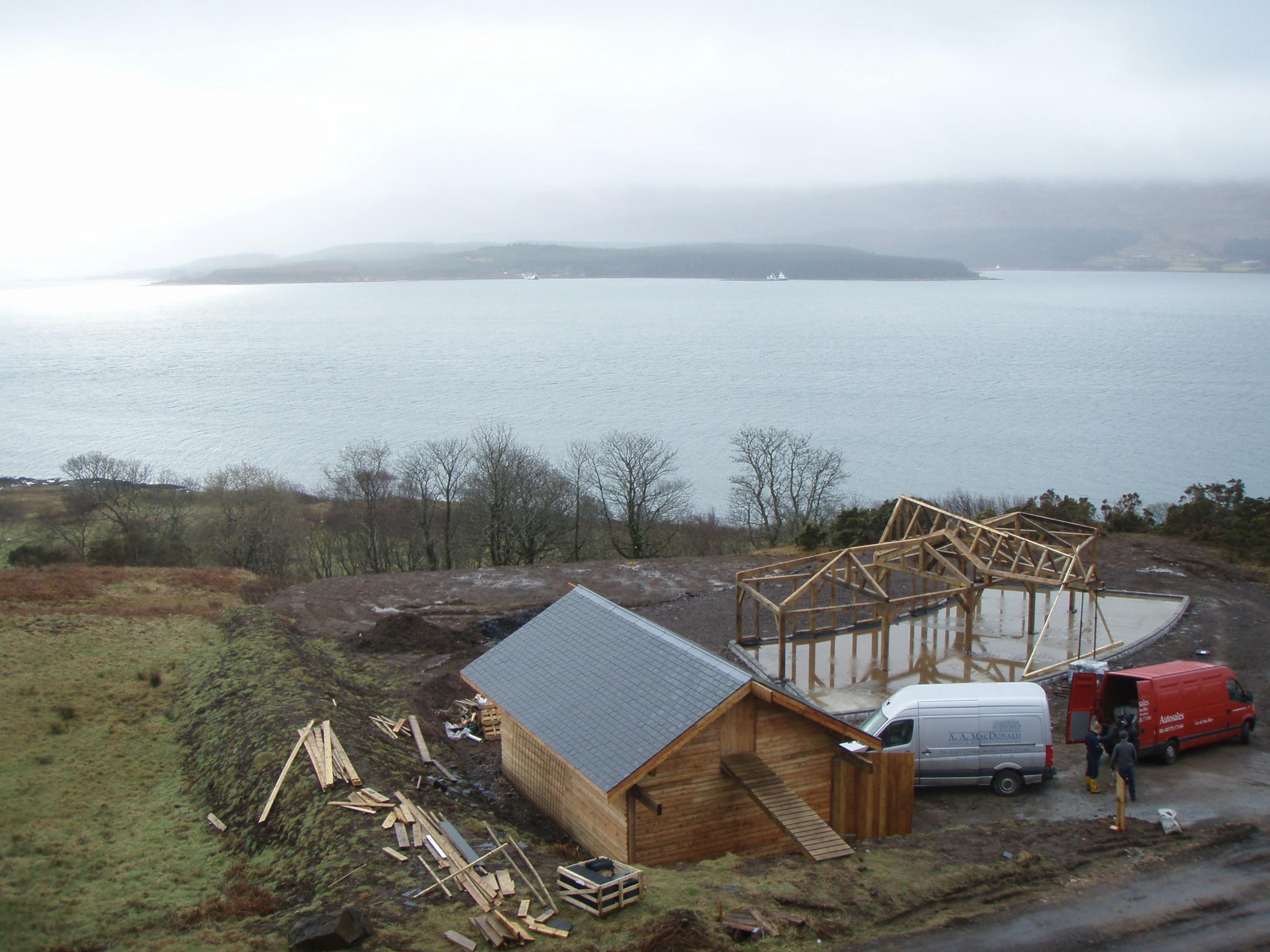 Site installation of a curved oak-framed family home overlooking a picturesque loch in Scotland