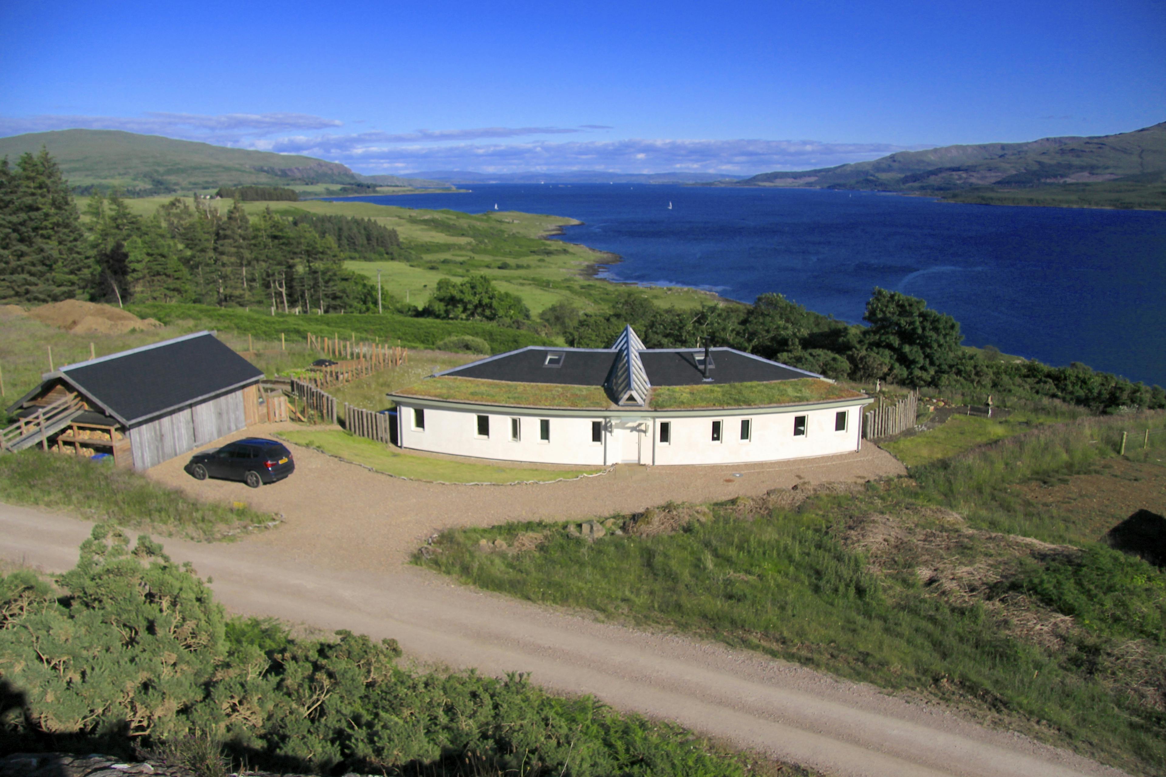 Oak-framed, facet-curved family house with a green roof