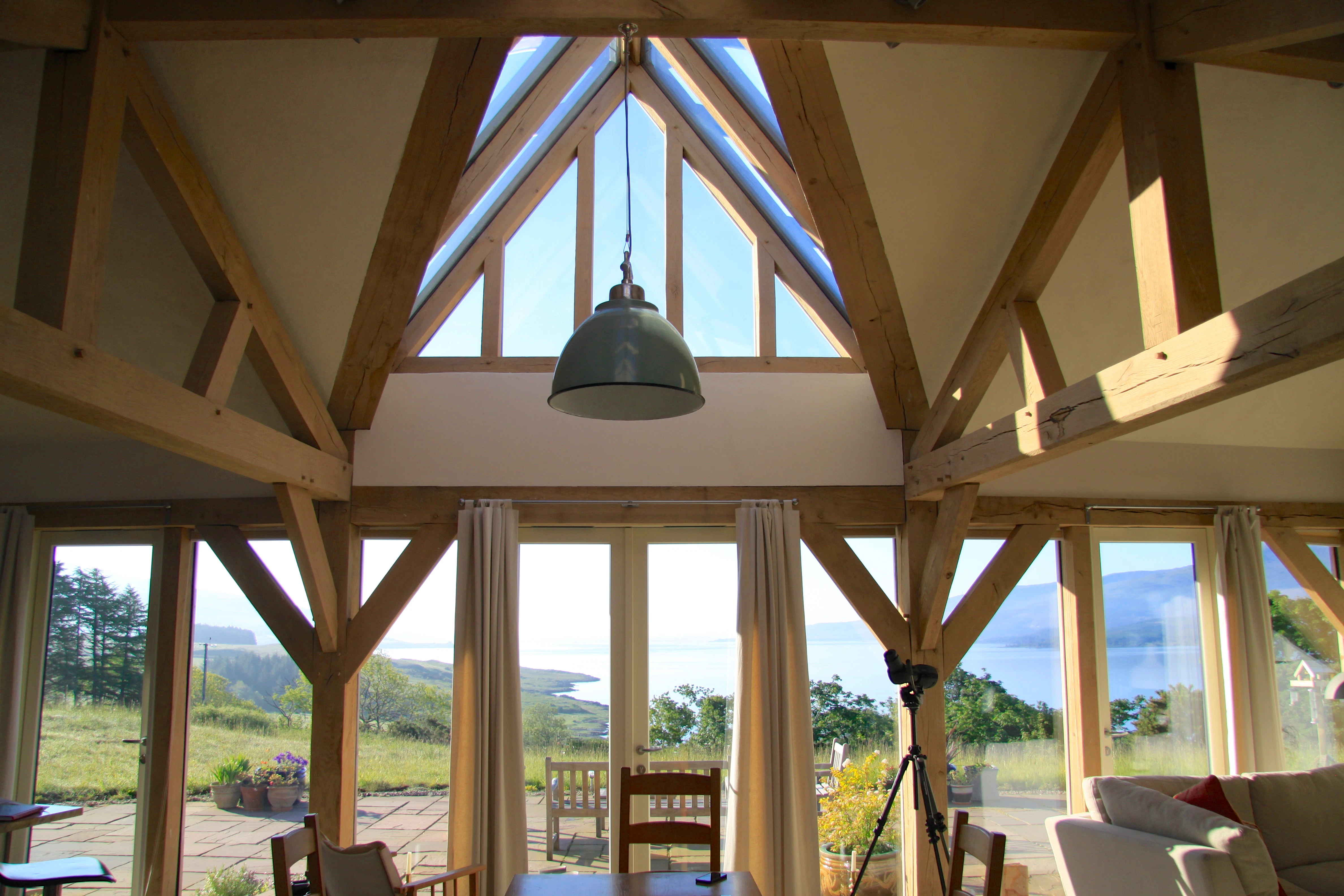Interior view of a curved oak-framed family home with a unique pitched glazed roof lantern