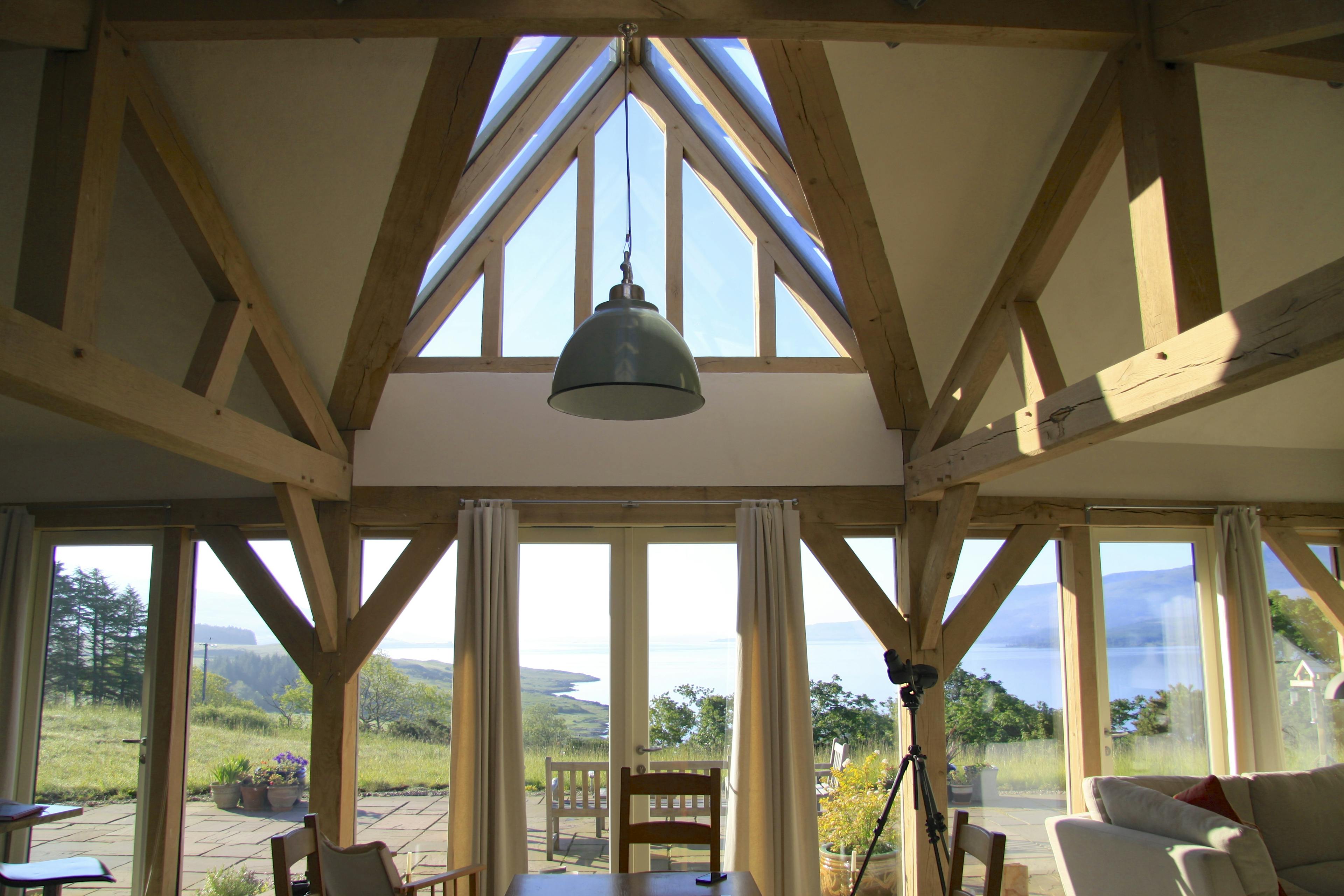 Interior view of a curved oak-framed family home with a unique pitched glazed roof lantern