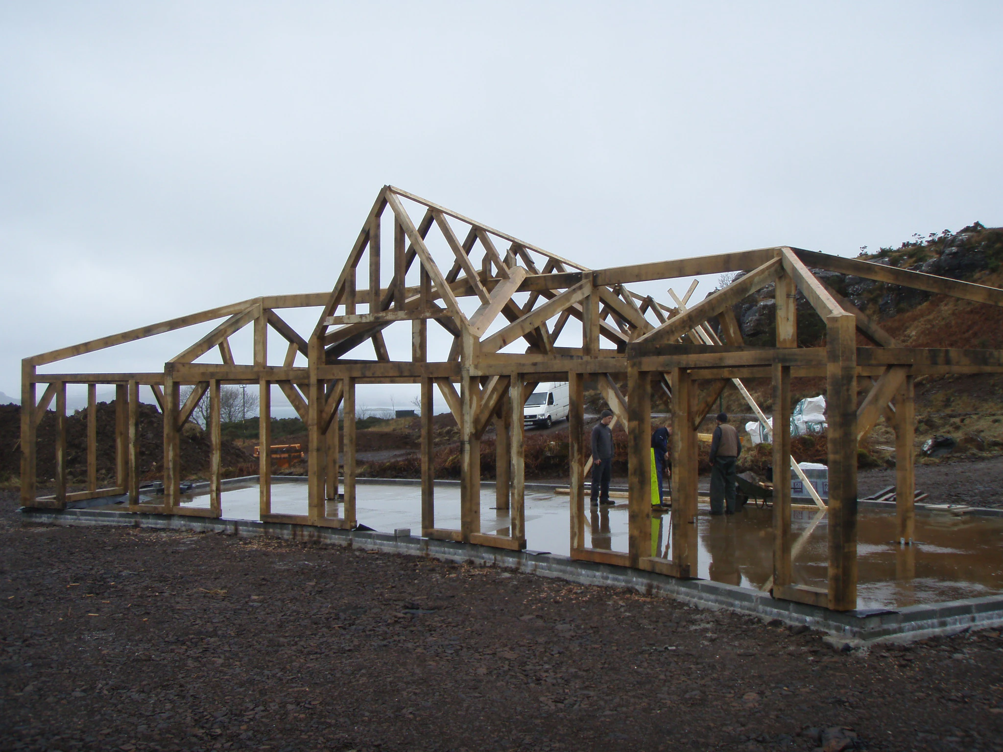 Site installation of a unique, curved oak-framed family home with a pitched central roof lantern