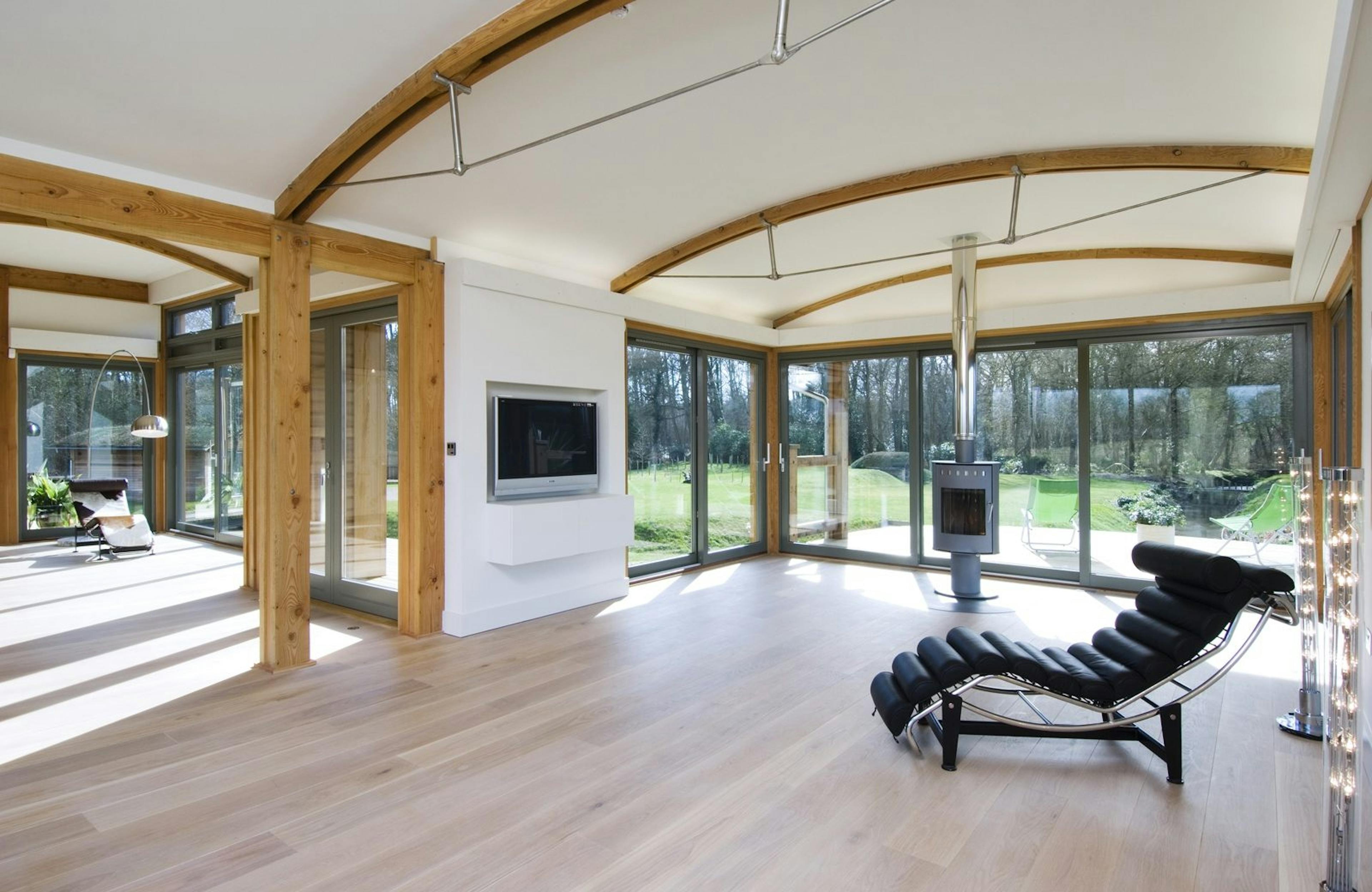 Interior of a Douglas Fir-Framed Eco-Friendly Family Home Featuring Curved Trusses and Steel Fixtures