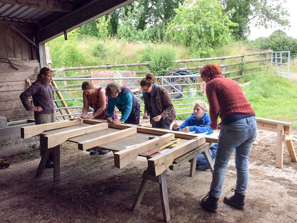 Astrid Arnold and female carpenters building a mini timber frame house