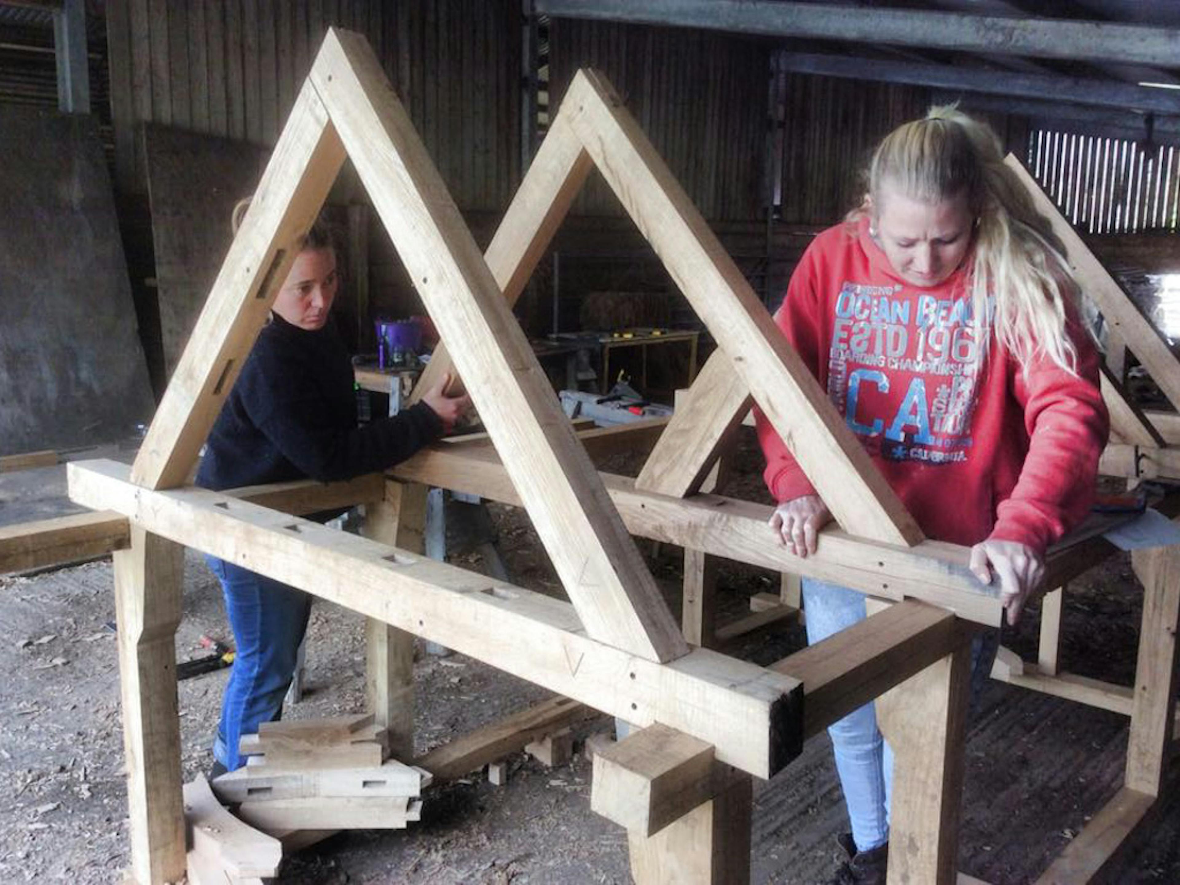 Astrid Arnold and female carpenters building a mini timber frame house