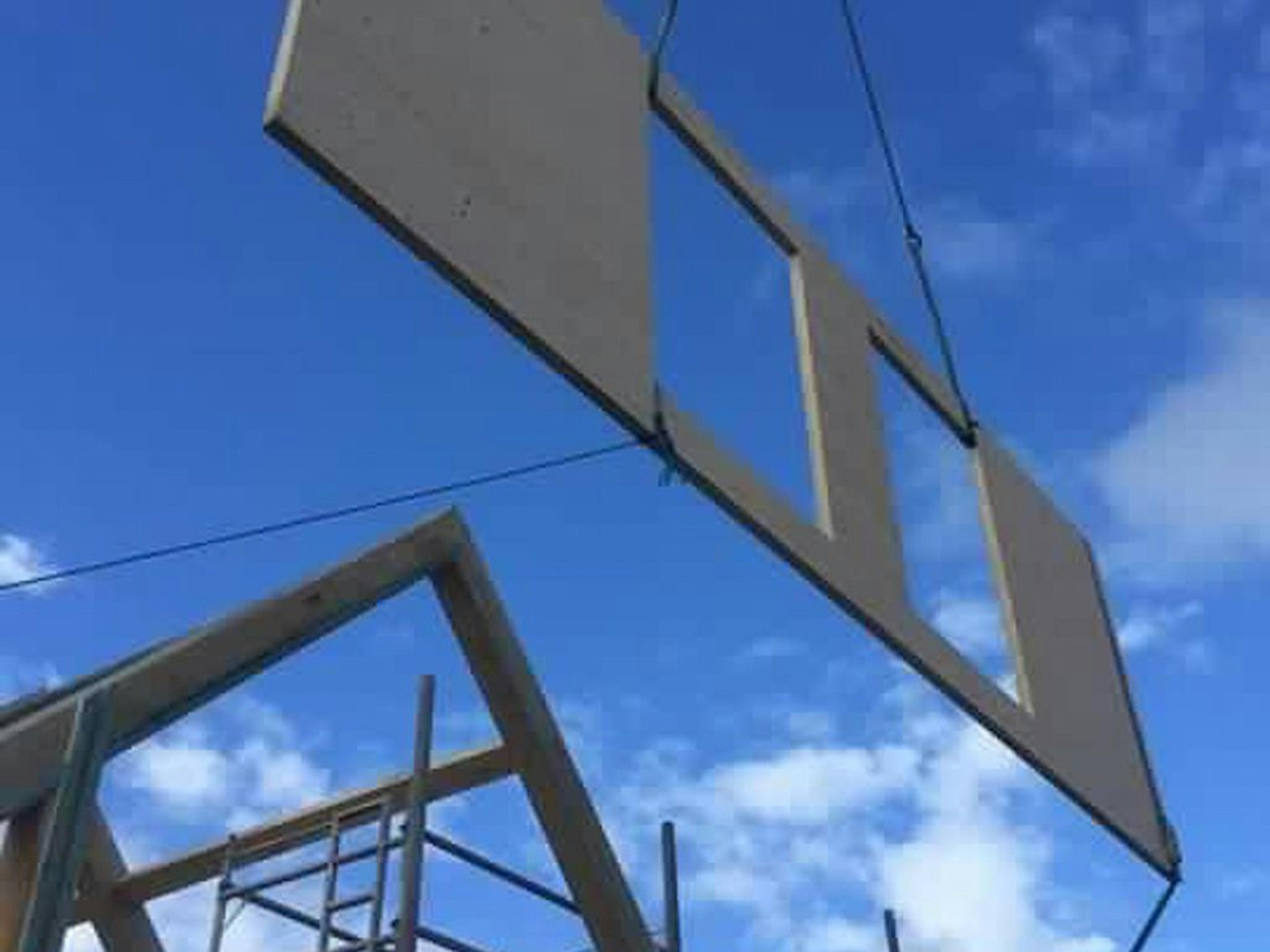 Positioning a panel to enclose the timber frame on site