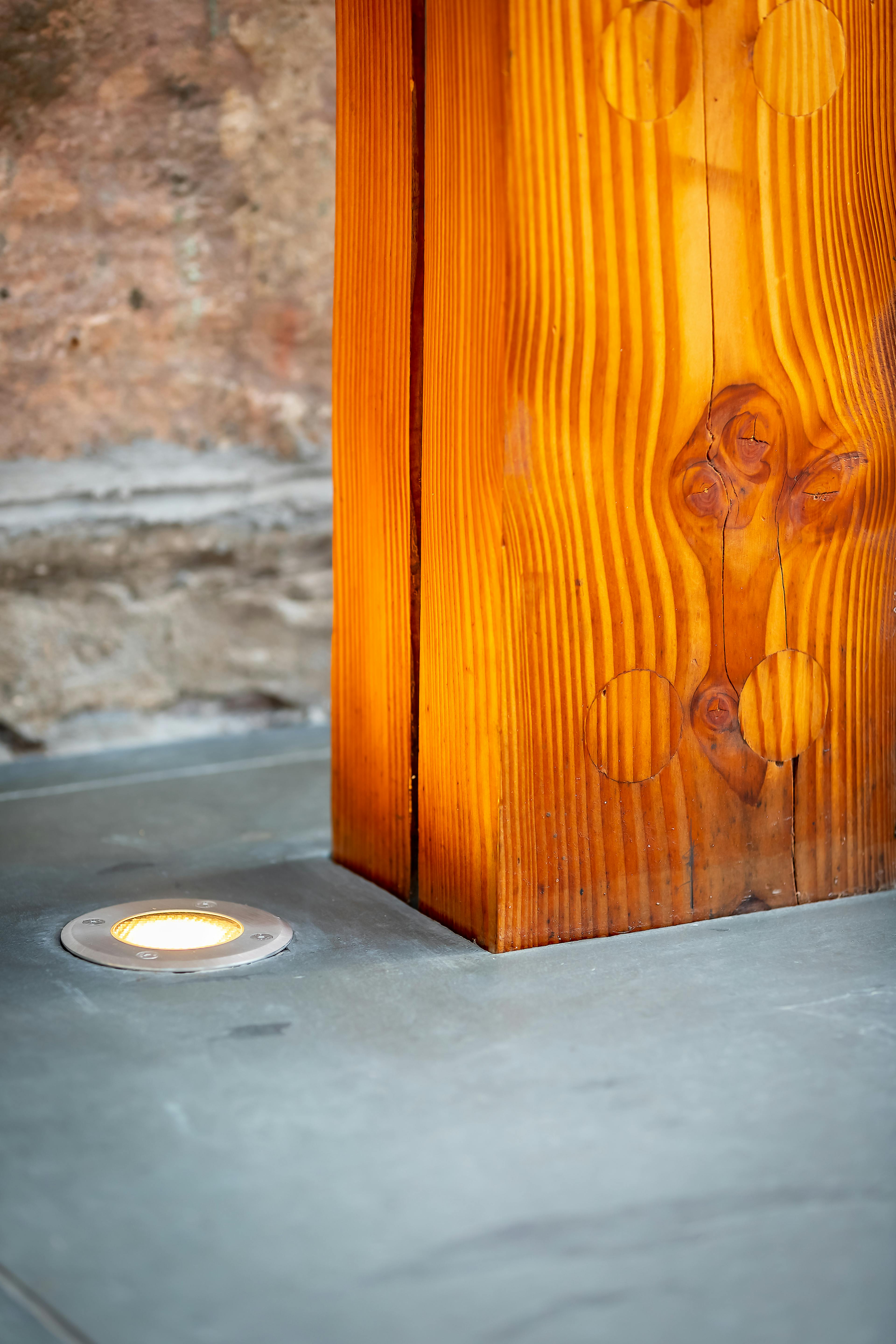 Close-up of a Douglas fir frame illuminated by floor lights, accentuating the wood's rich texture and natural grain