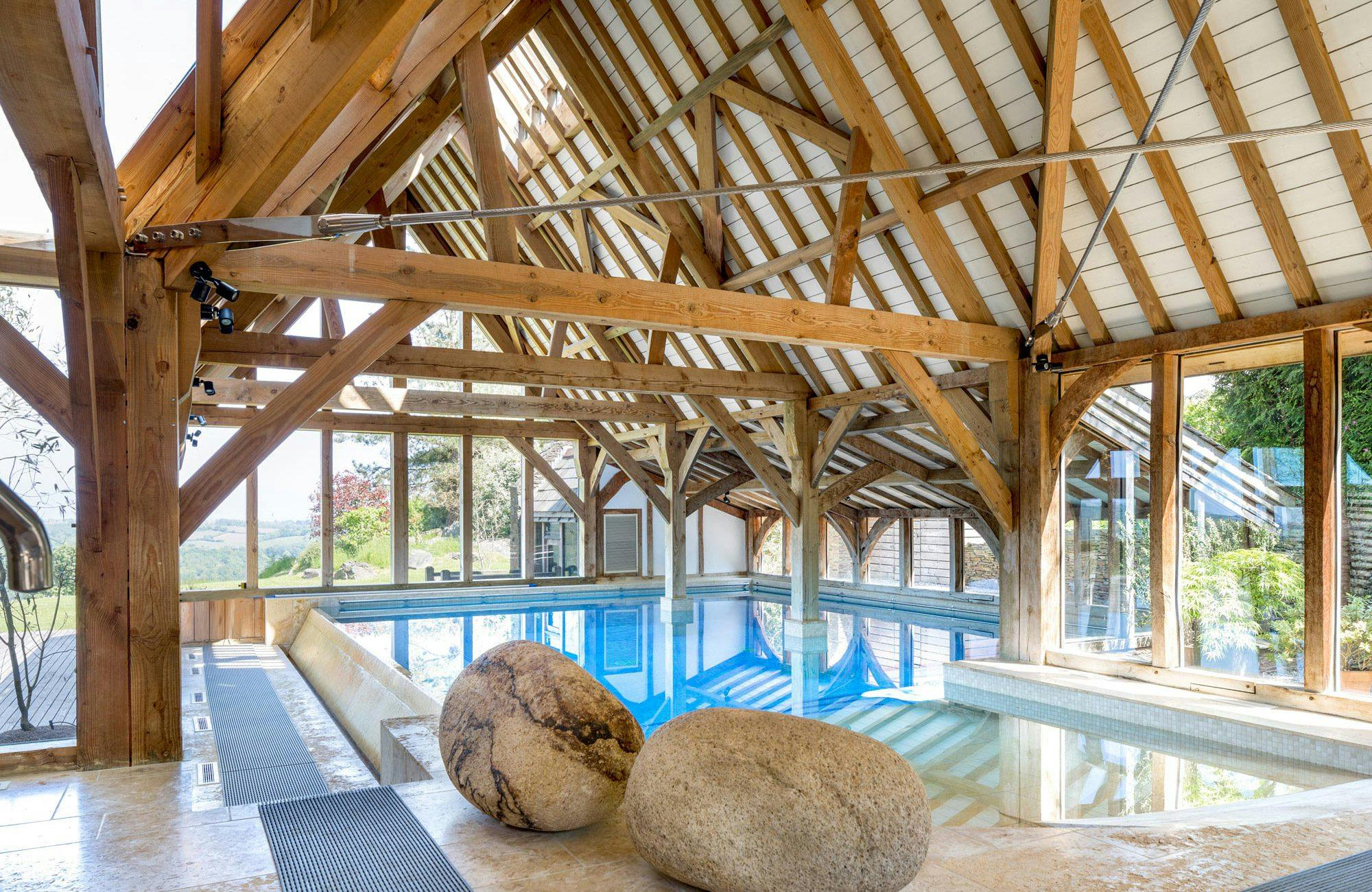 Traditional swimming pool surrounded by an Douglas fir framed structure
