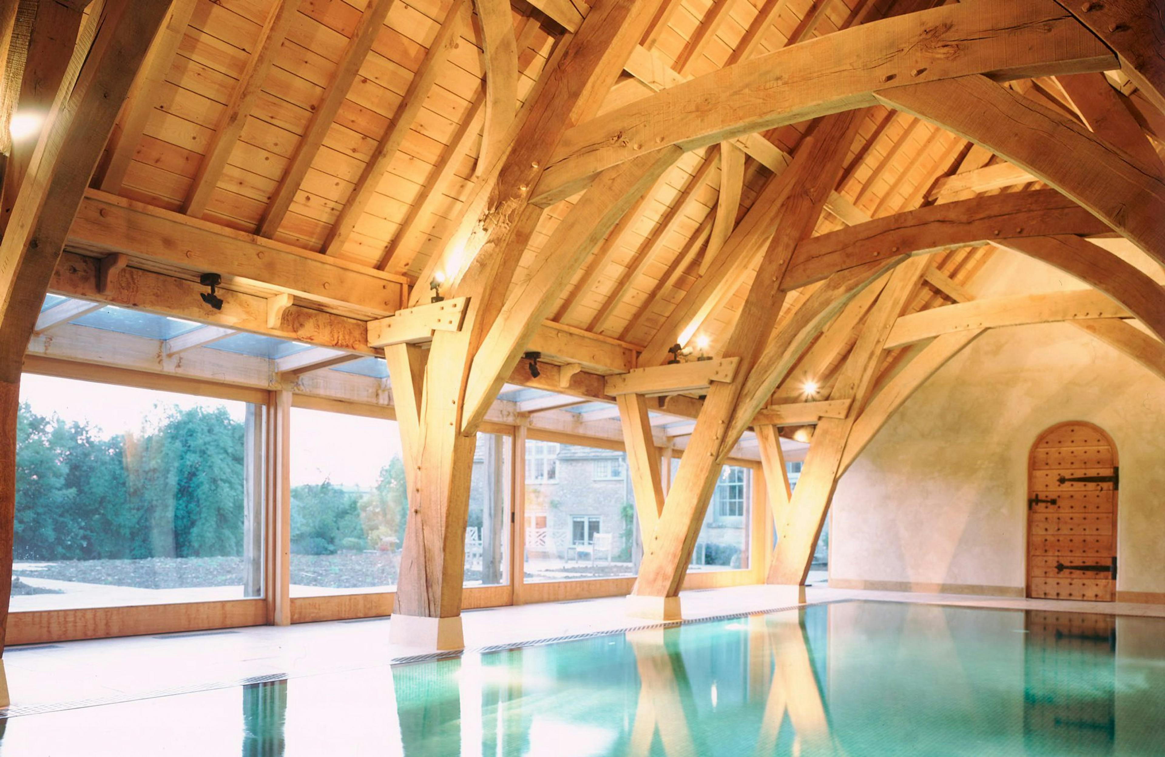 Internal view of a swimming pool enclosed by a structural oak frame