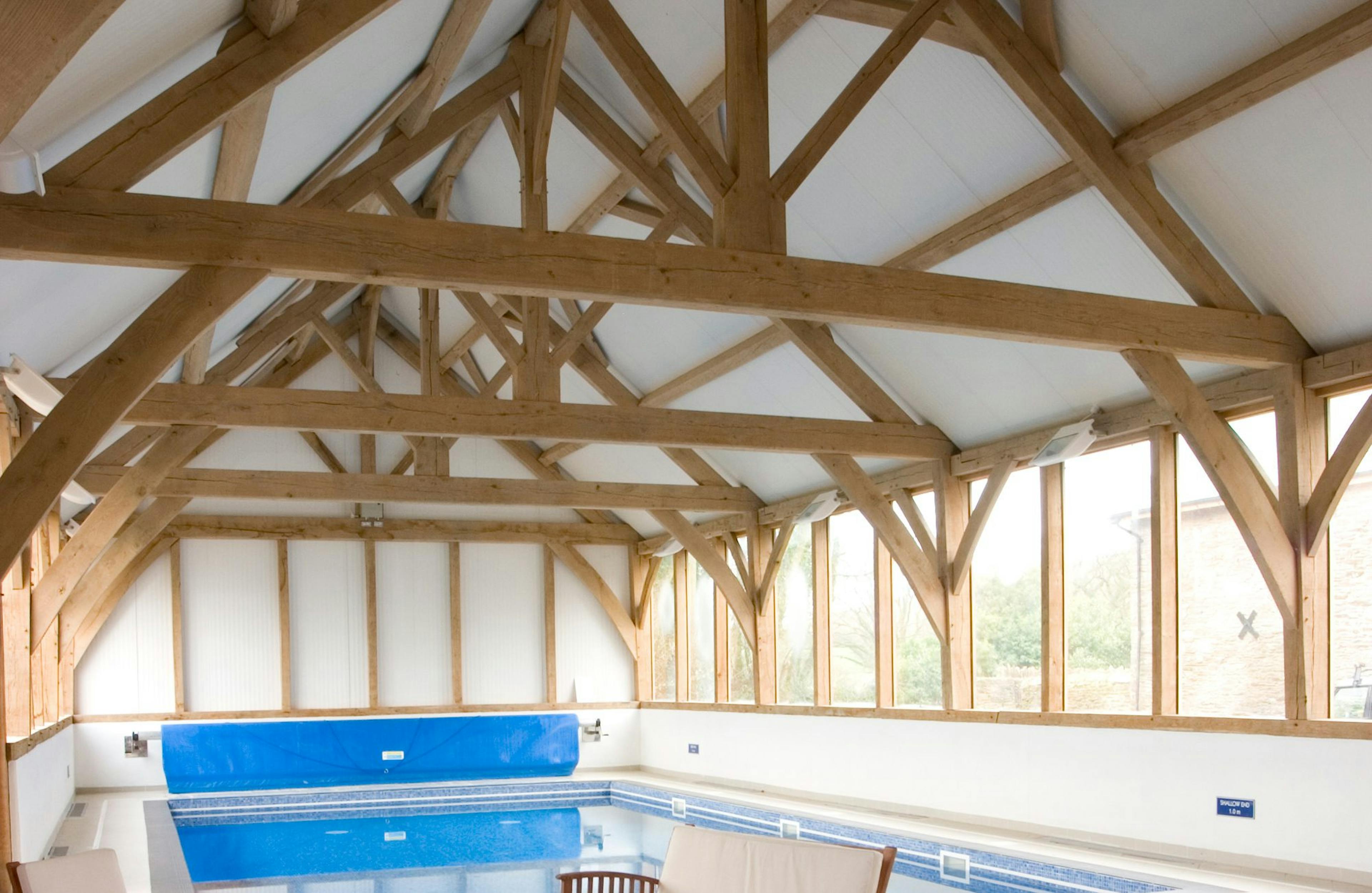 Internal view of a swimming pool surrounded by a structural oak frame