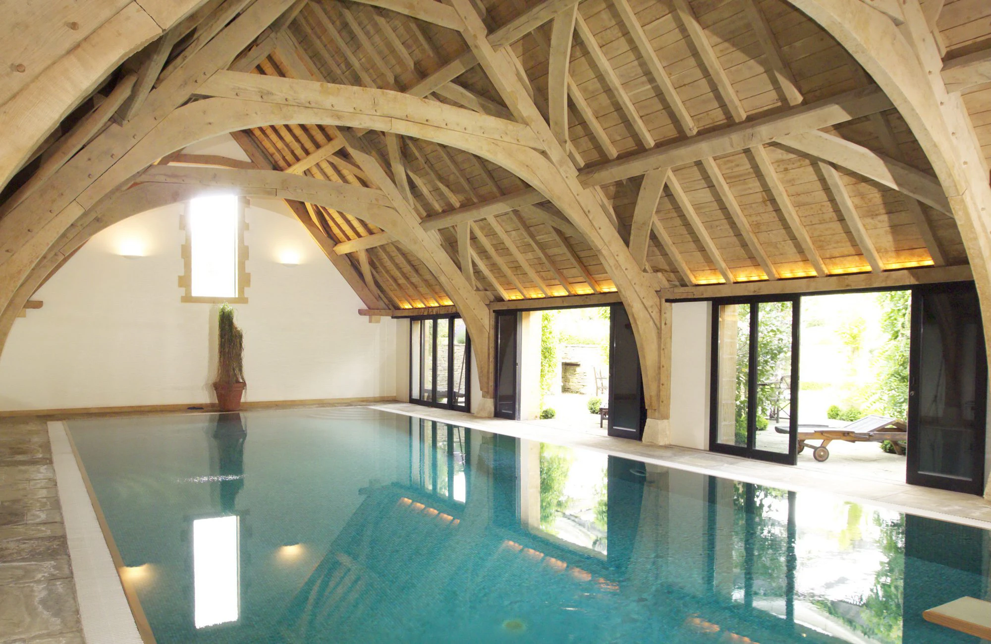 Swimming pool featuring arch-braced oak trusses, combining traditional design with modern elegance