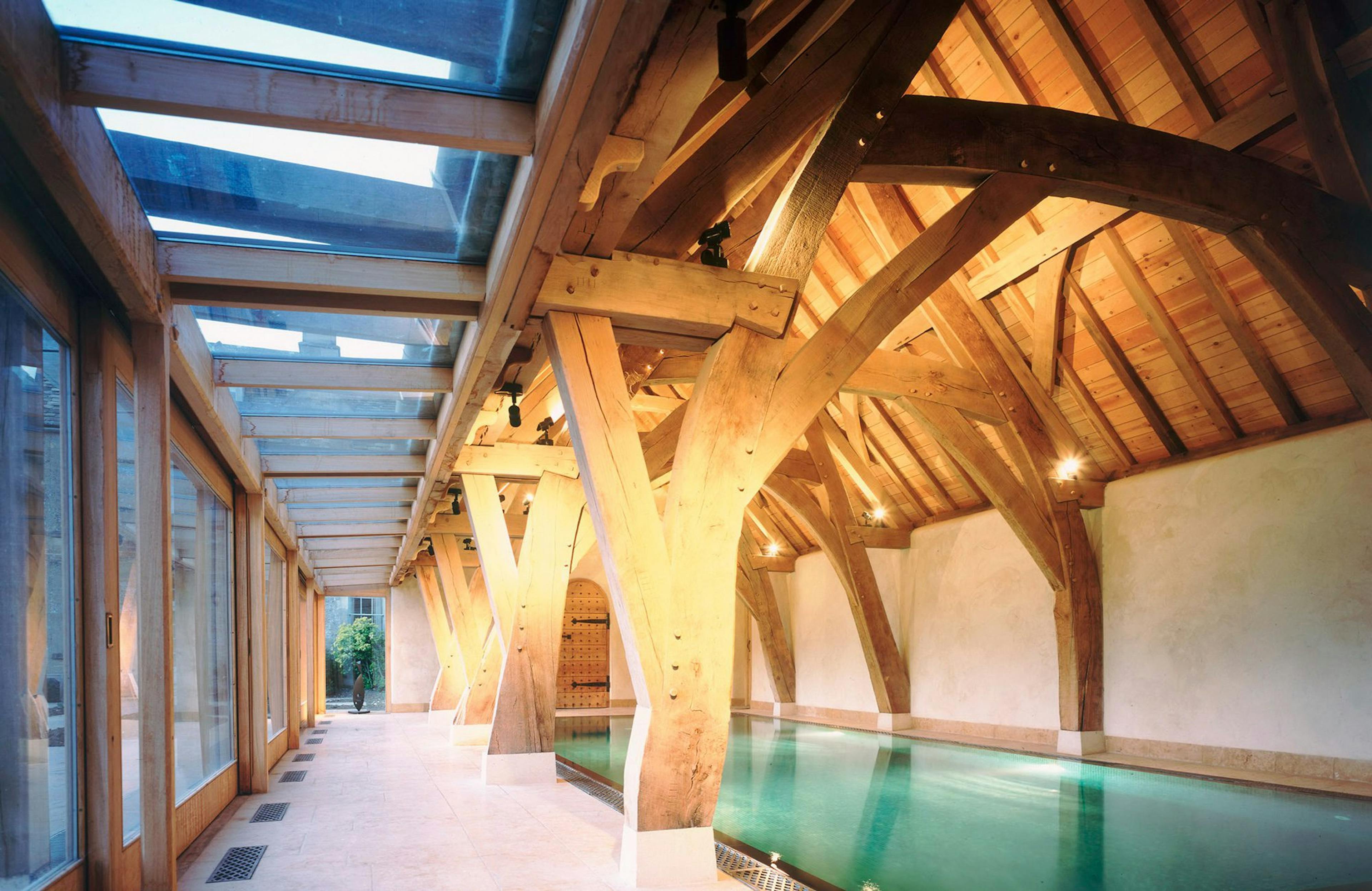 Oak-framed swimming pool featuring distinctive cruck trusses