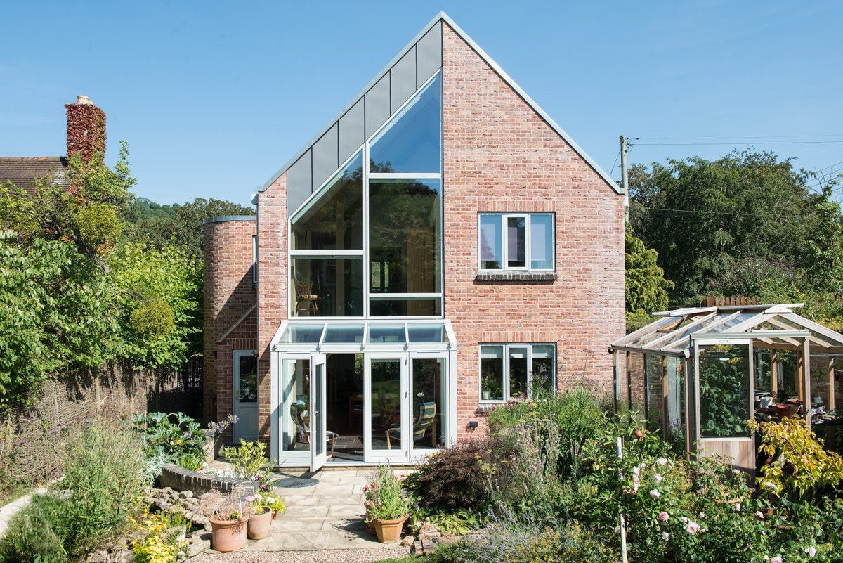 External view of an oak-framed family home with one side featuring large glazed panels