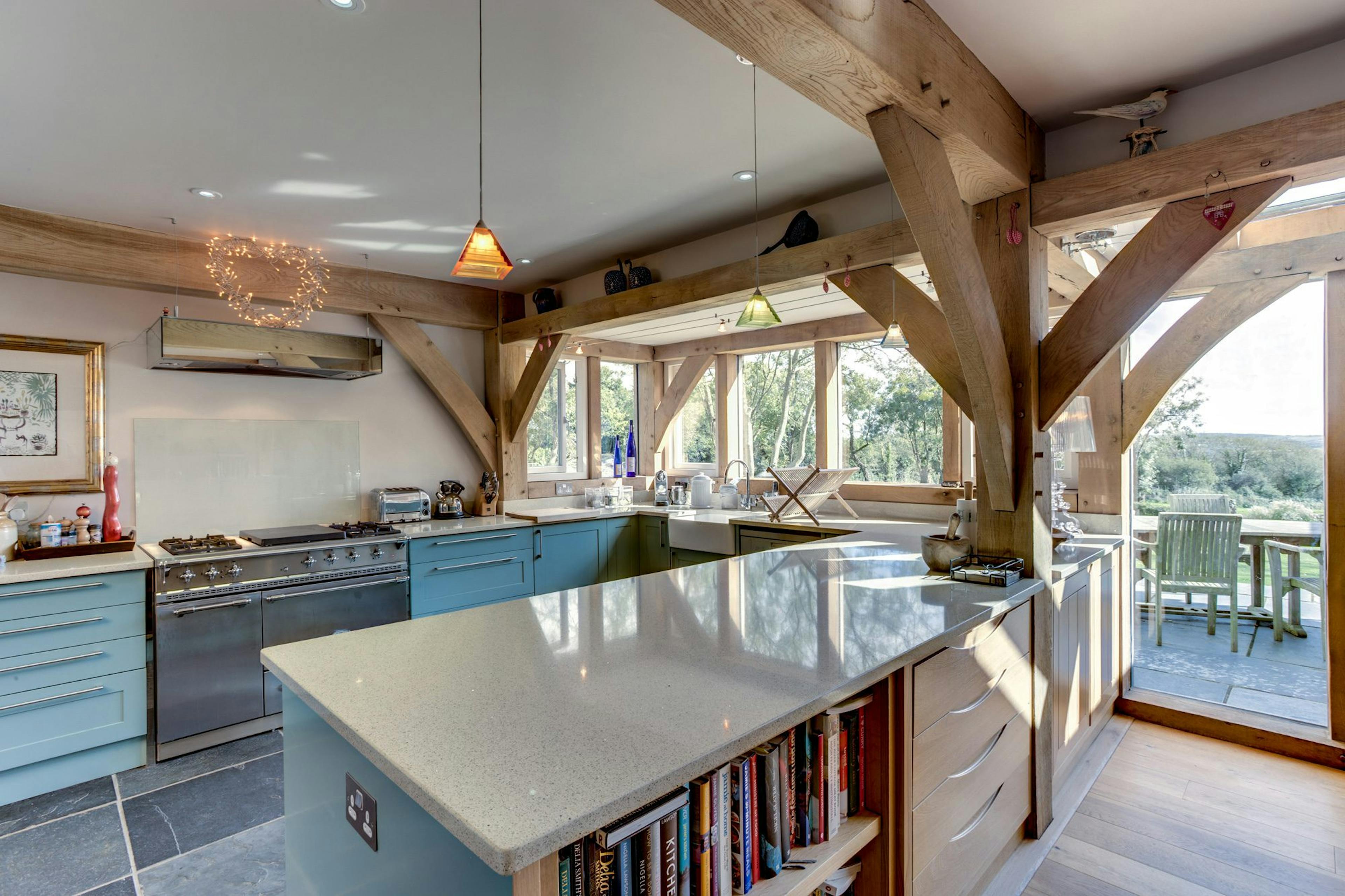 An open-plan kitchen and dining room space featuring oak-framed details, enhancing the room with rustic charm