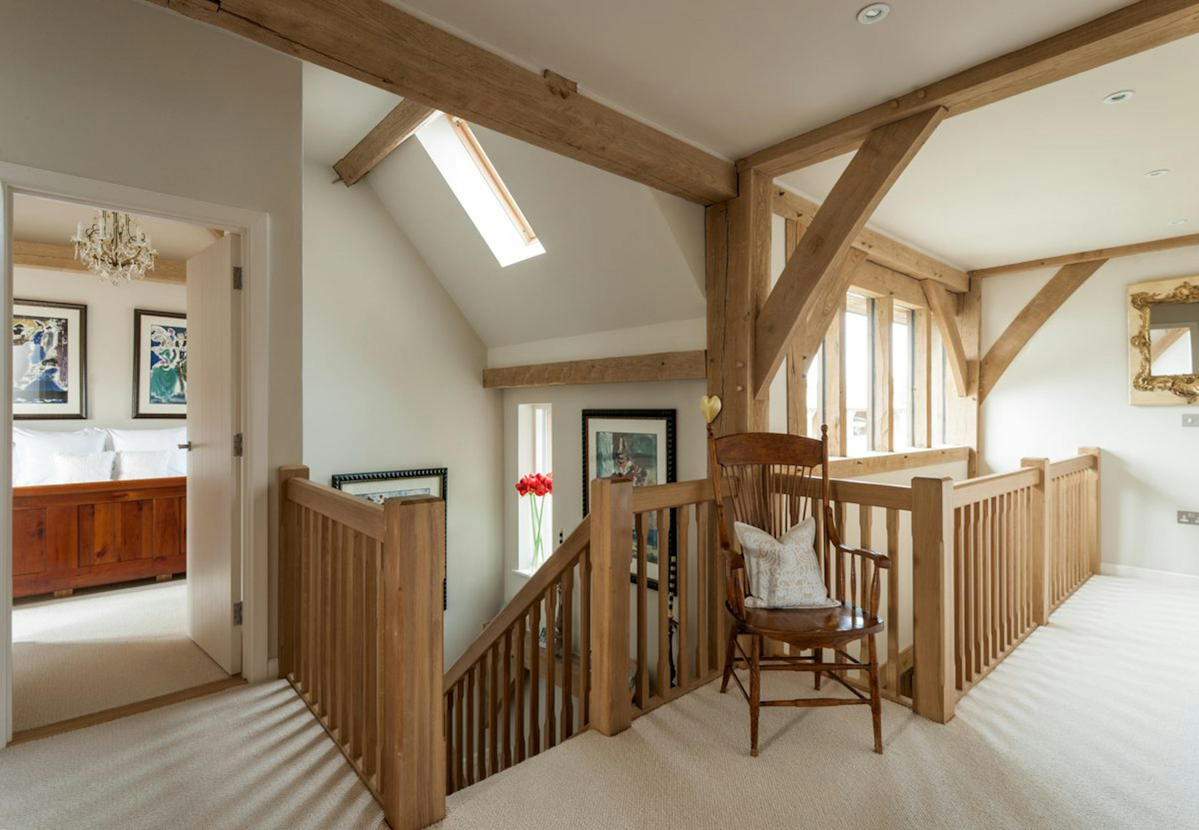 The top floor landing of an oak-framed family farmhouse, showcasing timber details and a light-filled, airy space