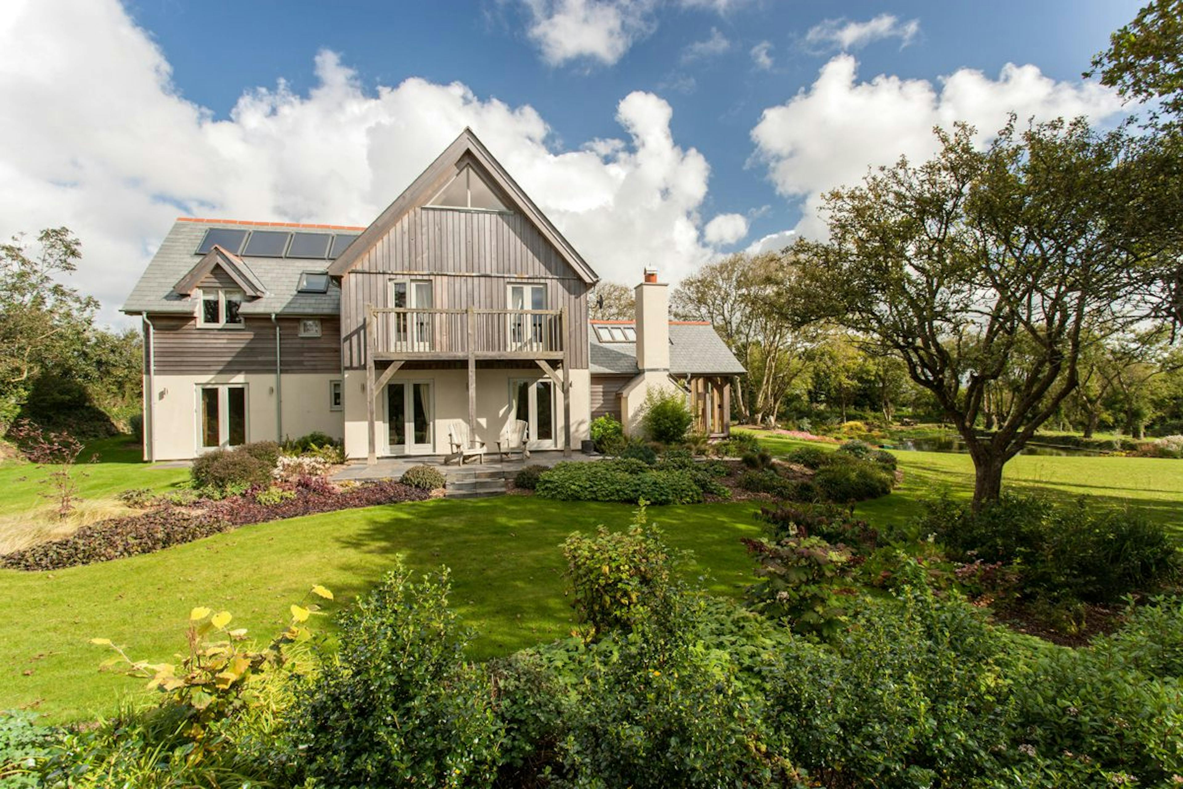 A Cornish oak-framed farmhouse finished with timber cladding, showcasing a blend of traditional design and countryside aesthetics