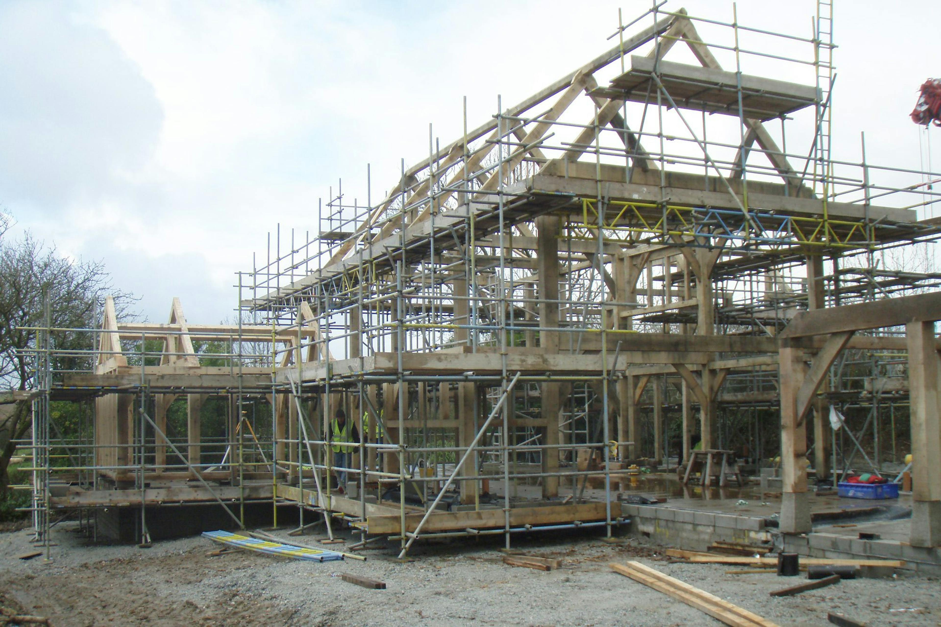 An oak-framed two-story family home being assembled on-site