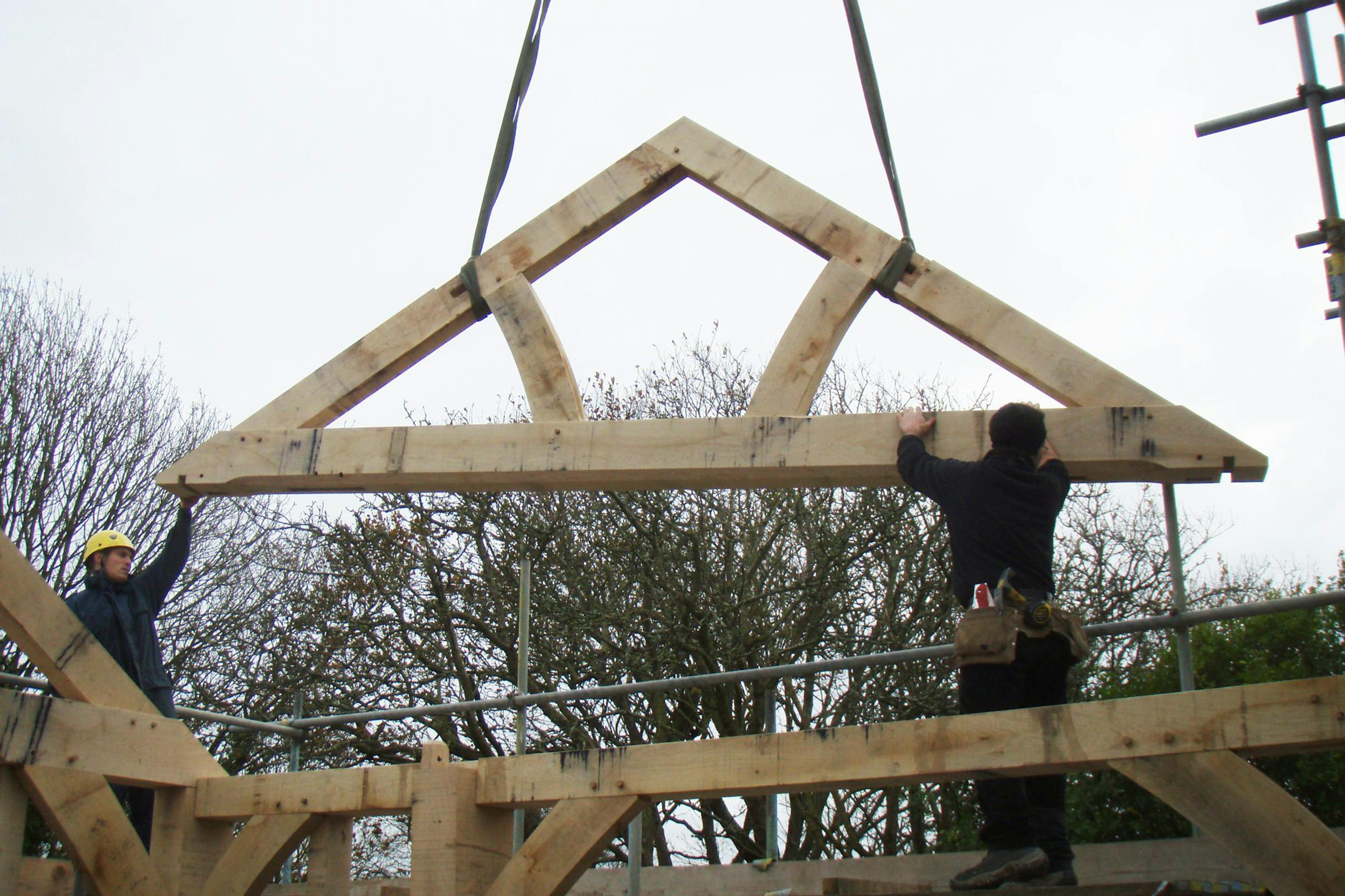 A queen post truss being installed on-site, part of the oak-framed structure 