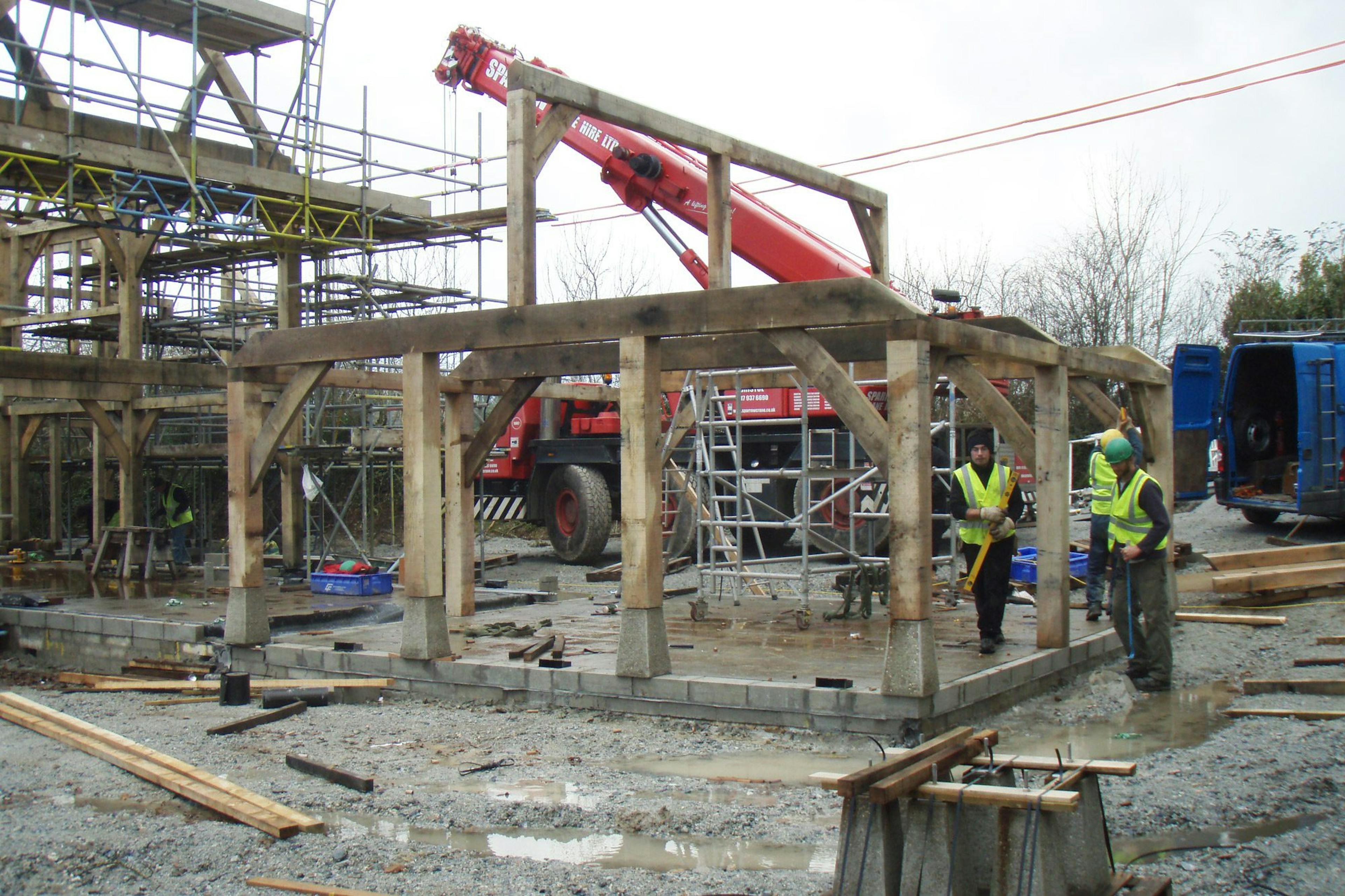 An oak-framed family home being constructed on-site, showcasing the process of building with timber