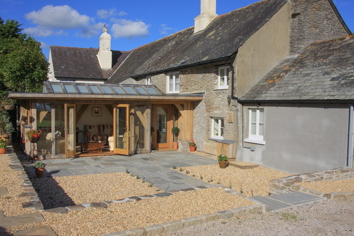 External view of a compact oak-framed extension featuring a large roof lantern