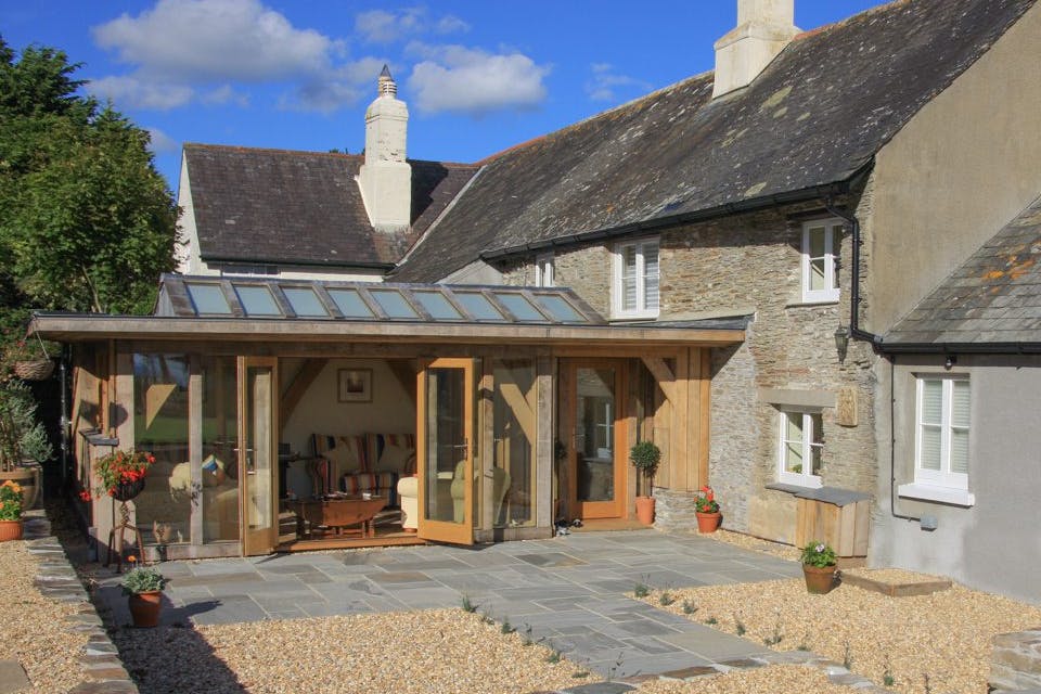 External view of a compact oak-framed extension featuring a large roof lantern