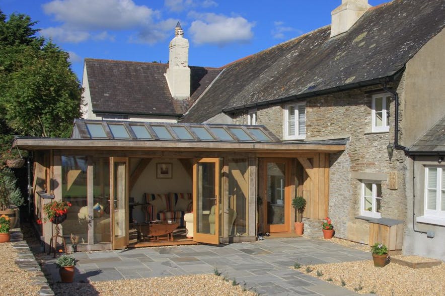 External view of a compact oak-framed extension featuring a large roof lantern