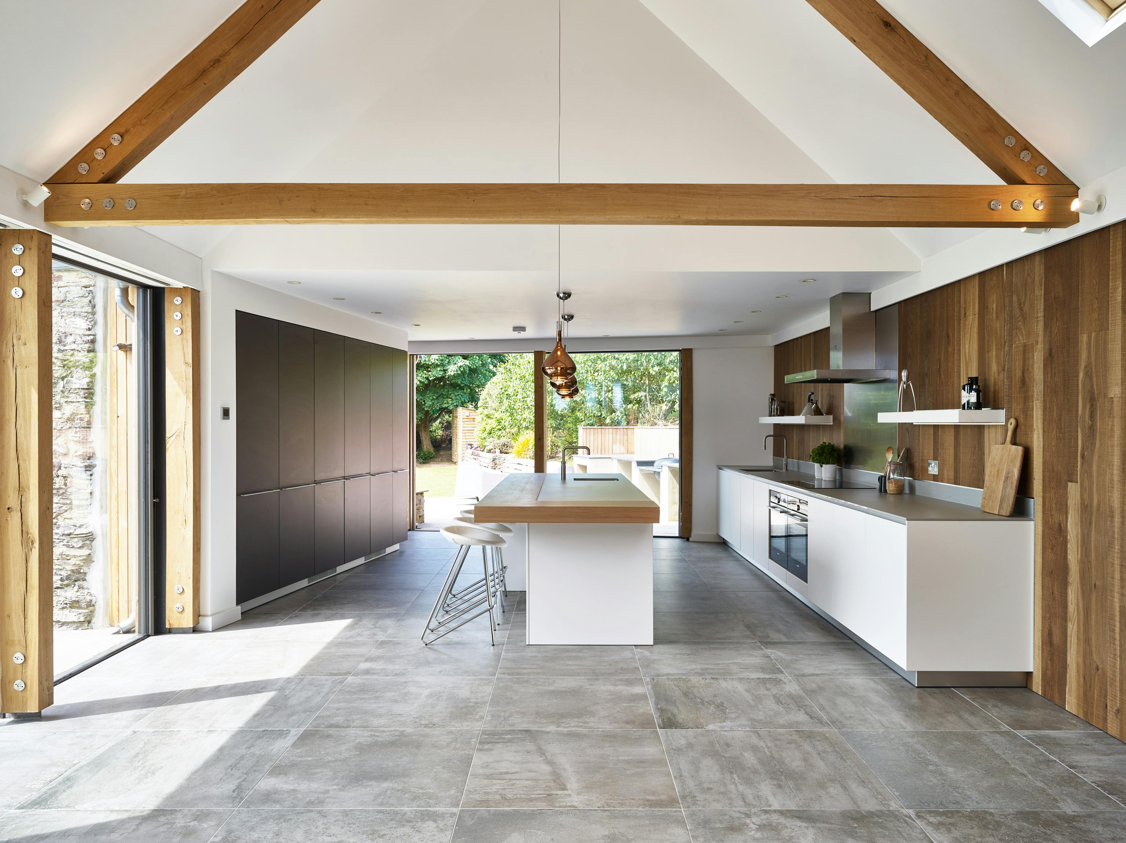 Vaulted kitchen and dining area with exposed planed oak trusses and steel fixings