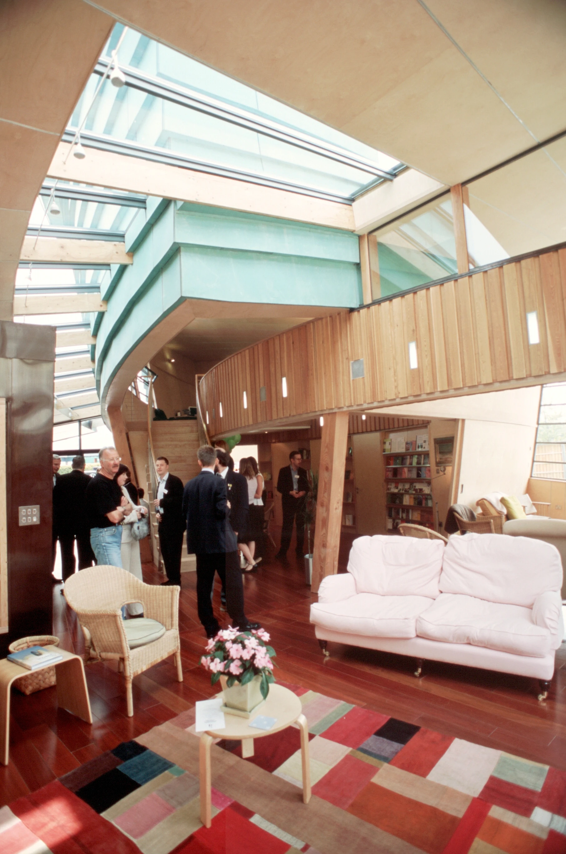 Interior of the Maggie's Centre at Raigmore Hospital in Inverness, featuring a curved mezzanine and a large roof lantern that floods the space with natural light