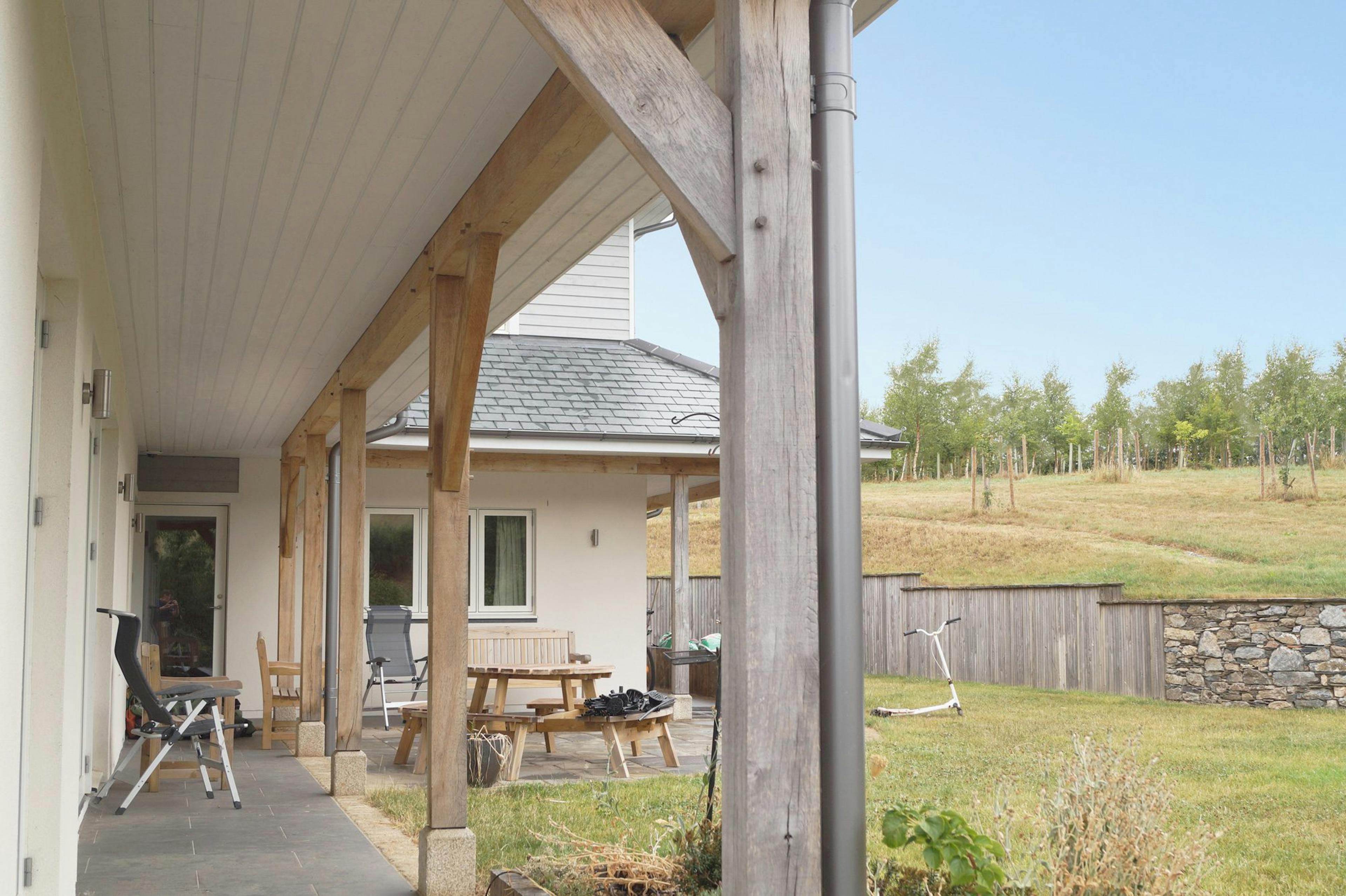 Wraparound veranda on a New England-style, two-storey oak-framed home