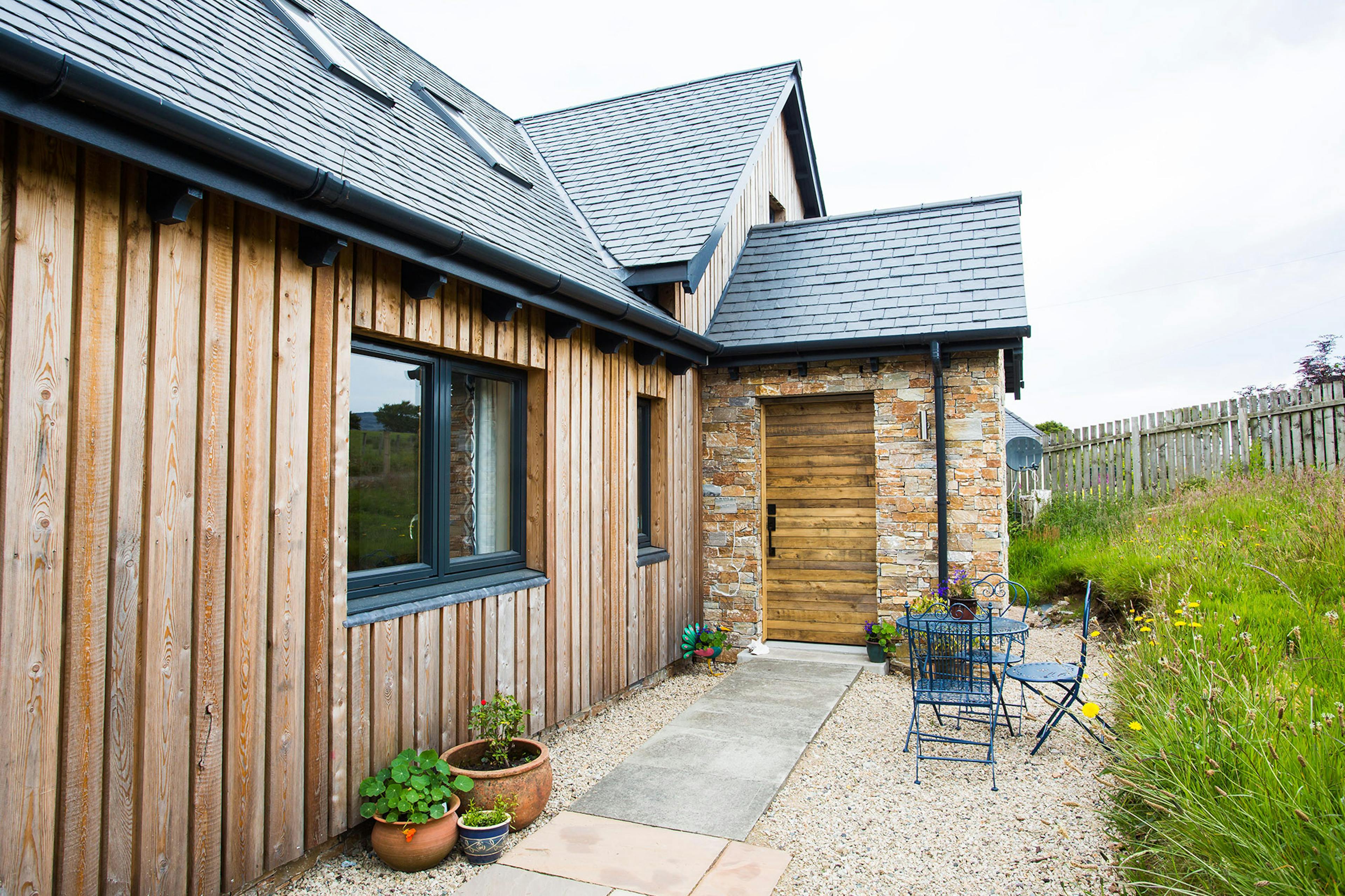 Entrance to an oak-framed family home with timber cladding, offering a warm, rustic aesthetic