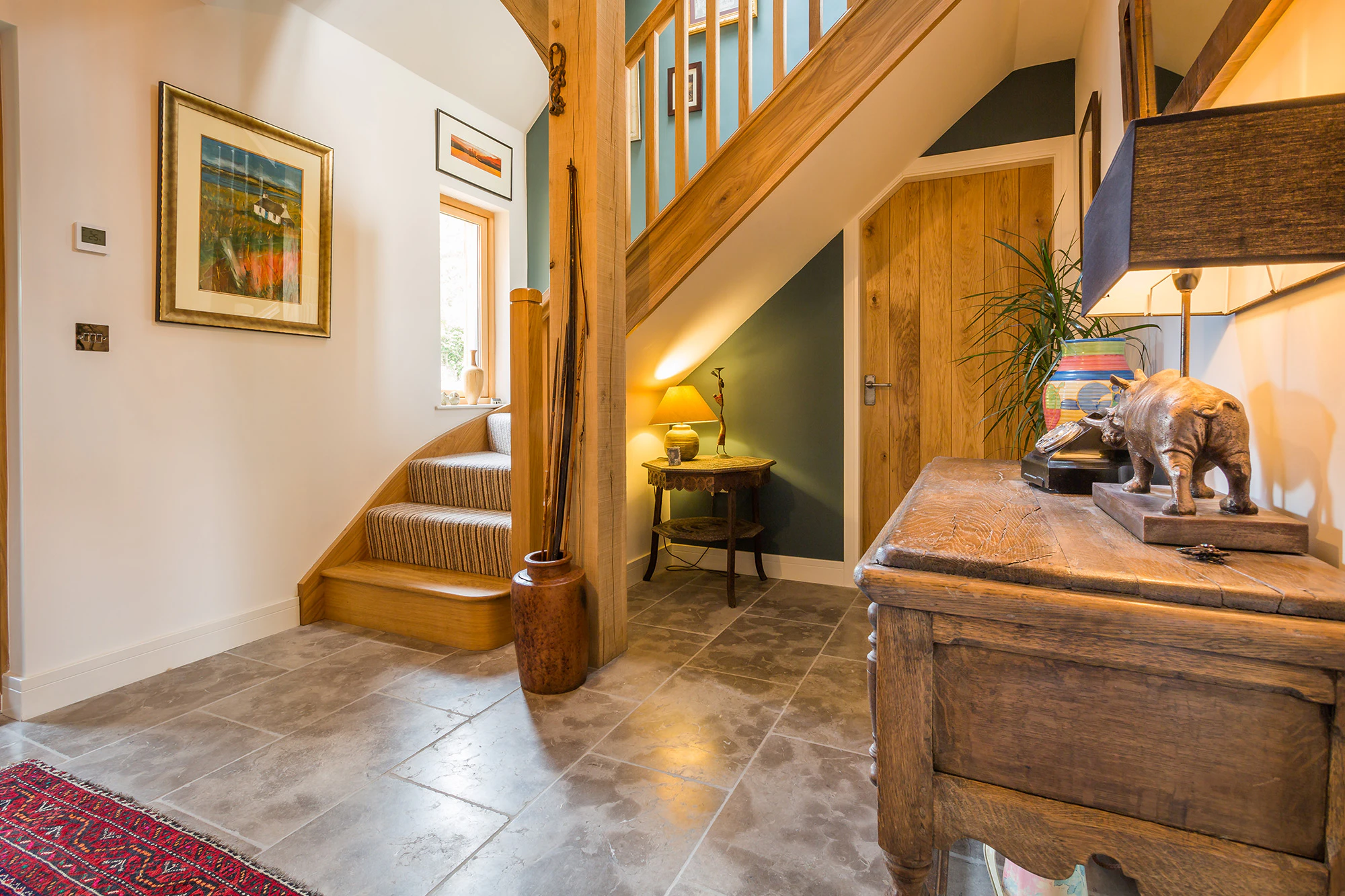 Internal view of the foyer inside an oak-framed family home with a warm, welcoming design