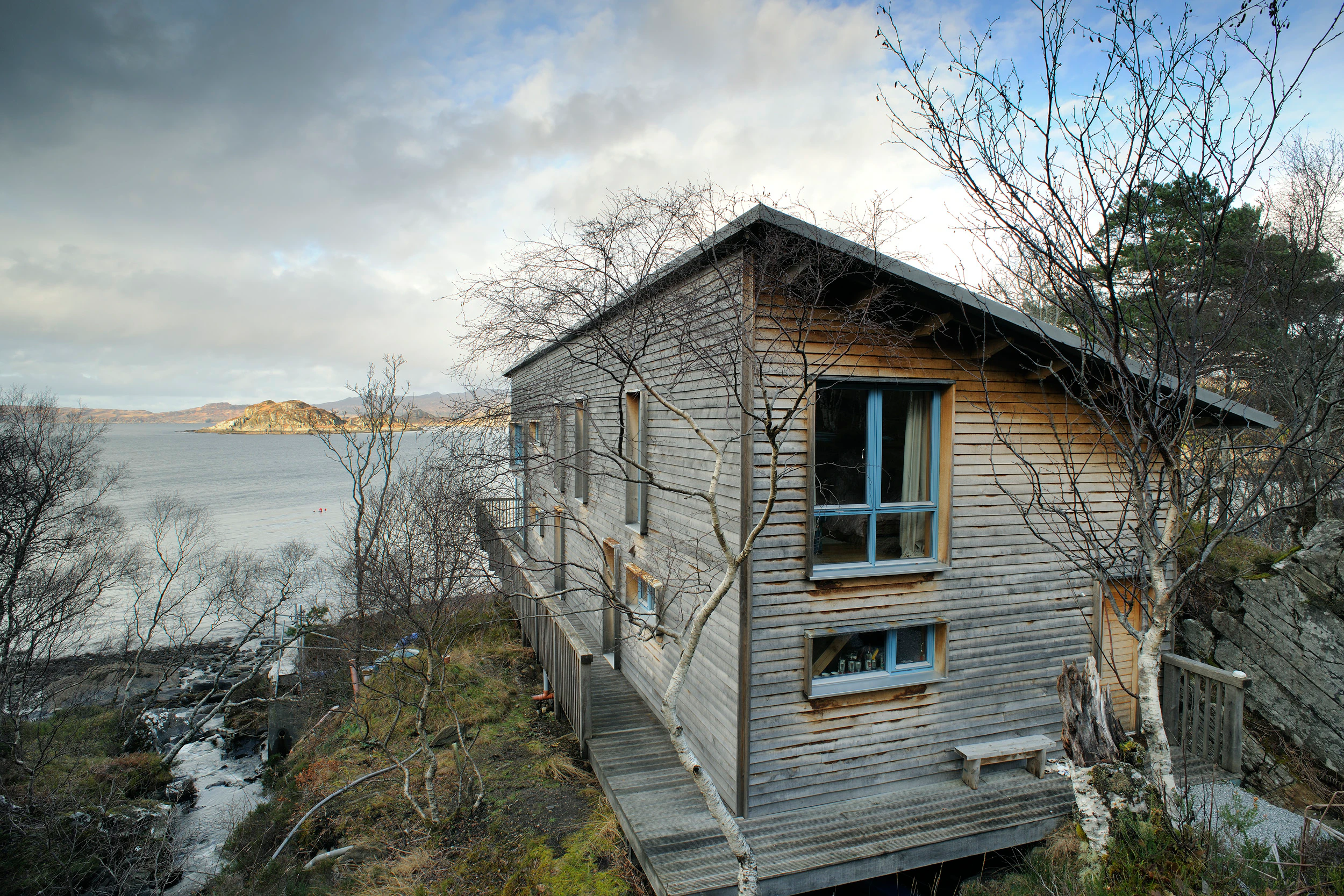 A structural Douglas fir-framed eco-home on the shores of Loch Ailort, featuring oak feather-edge cladding that blends seamlessly into the surrounding moorland
