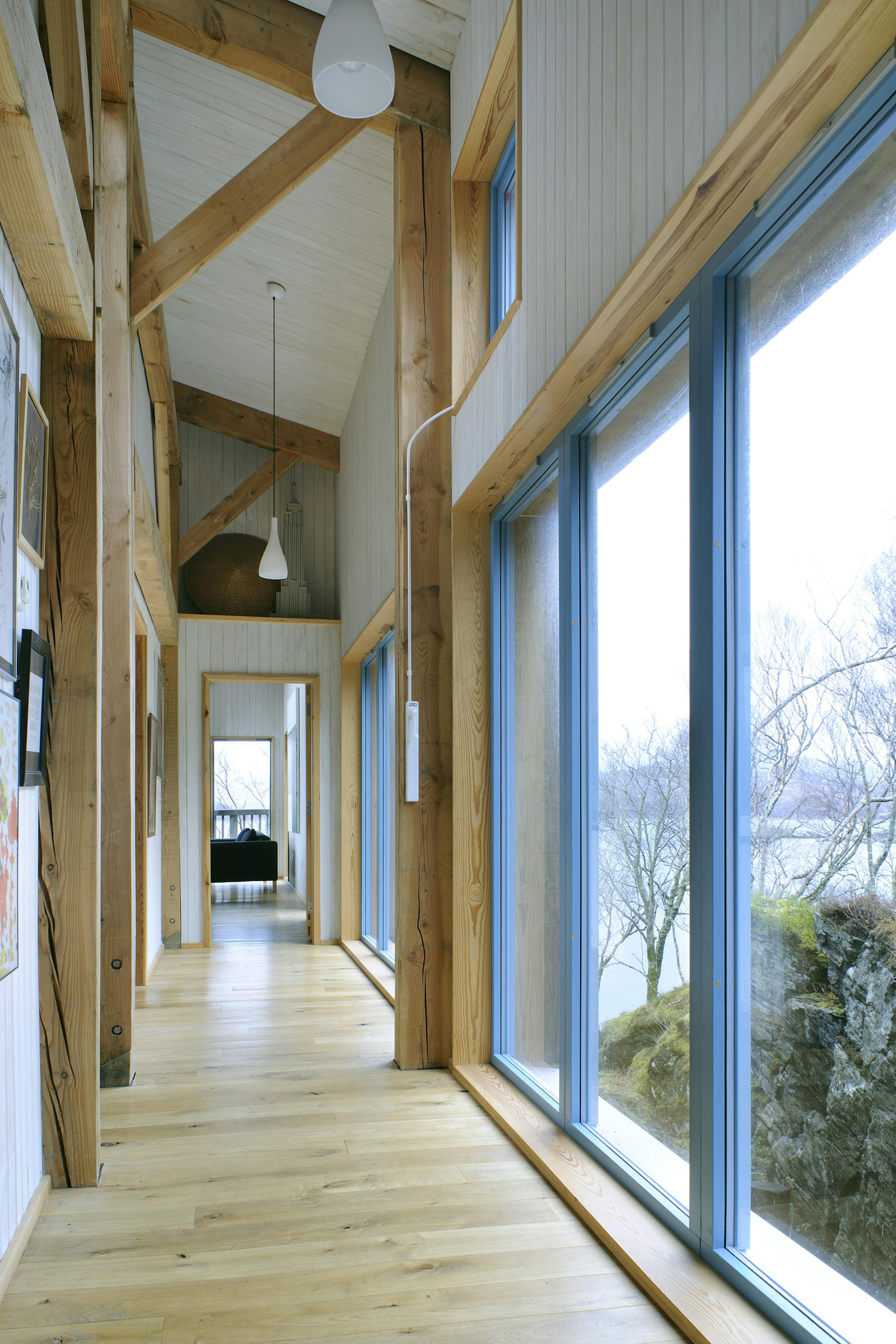 Internal view of a Douglas-fir framed home with panoramic views of Loch Ailort spanning the entire residence