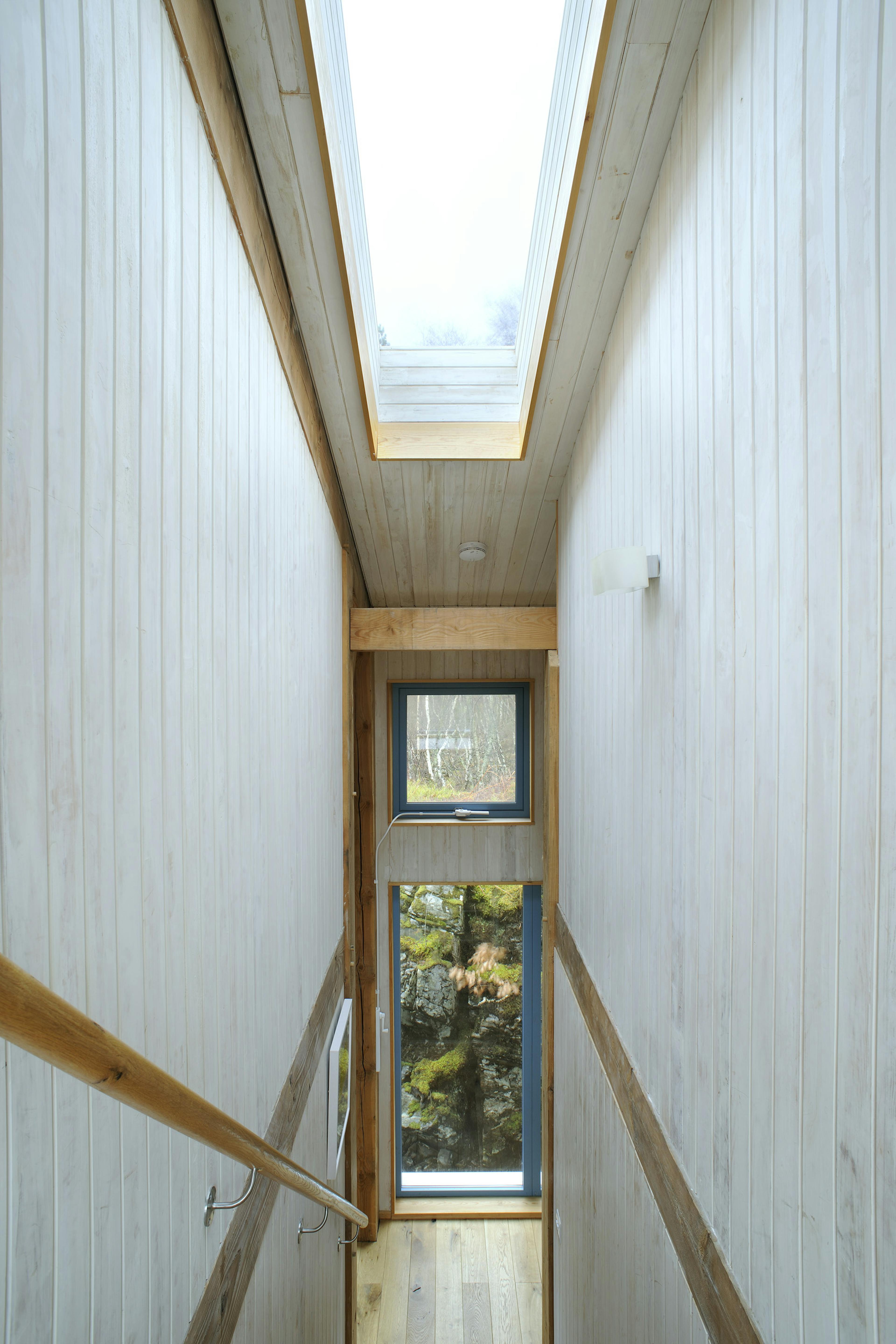 Internal view of a Douglas-fir framed home featuring vaulted ceilings in the staircase area and roof lanterns that flood the space with natural light