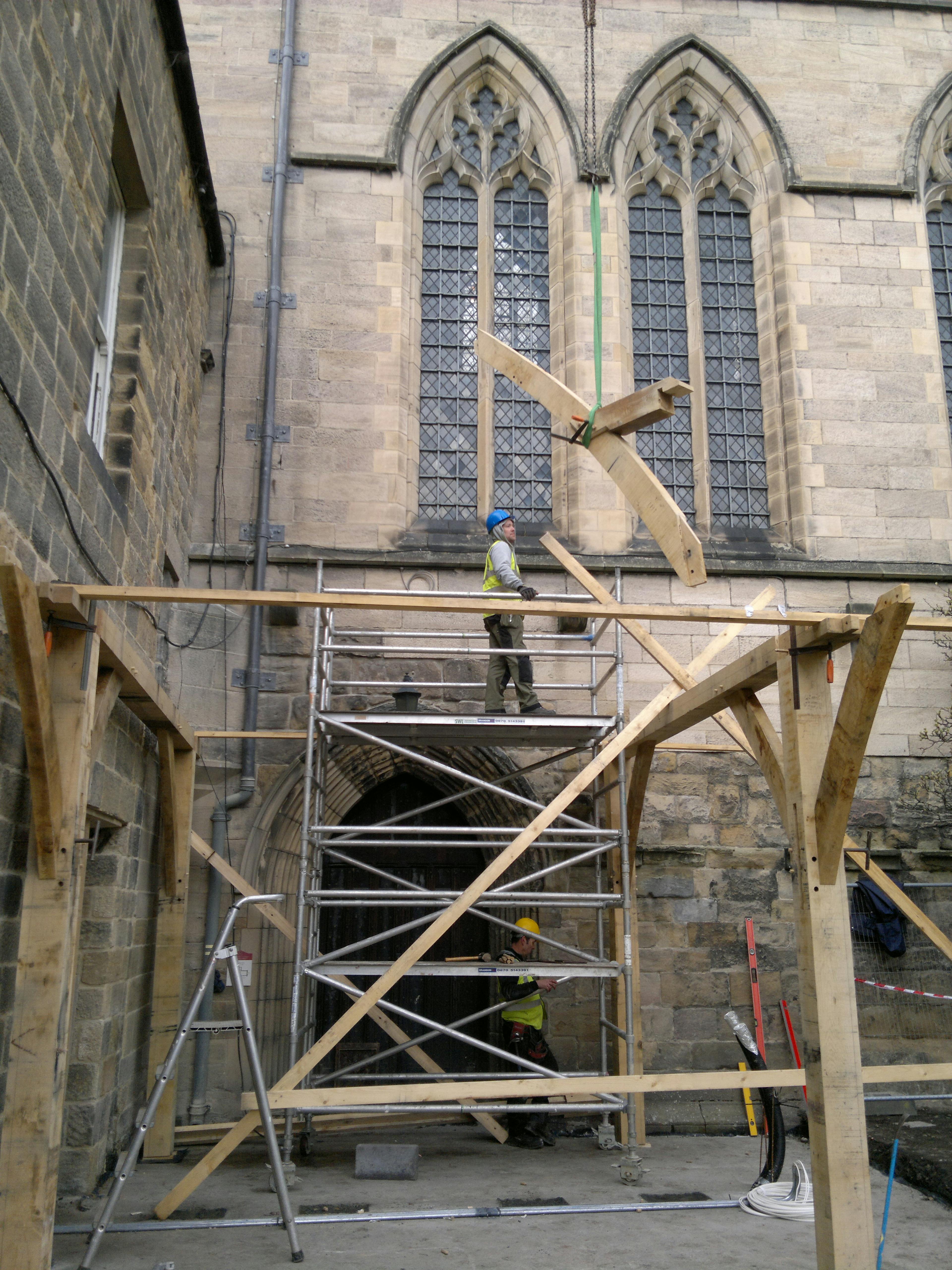 Positioning a lifting brace into place on the oak-framed cloister at Hexham Abbey