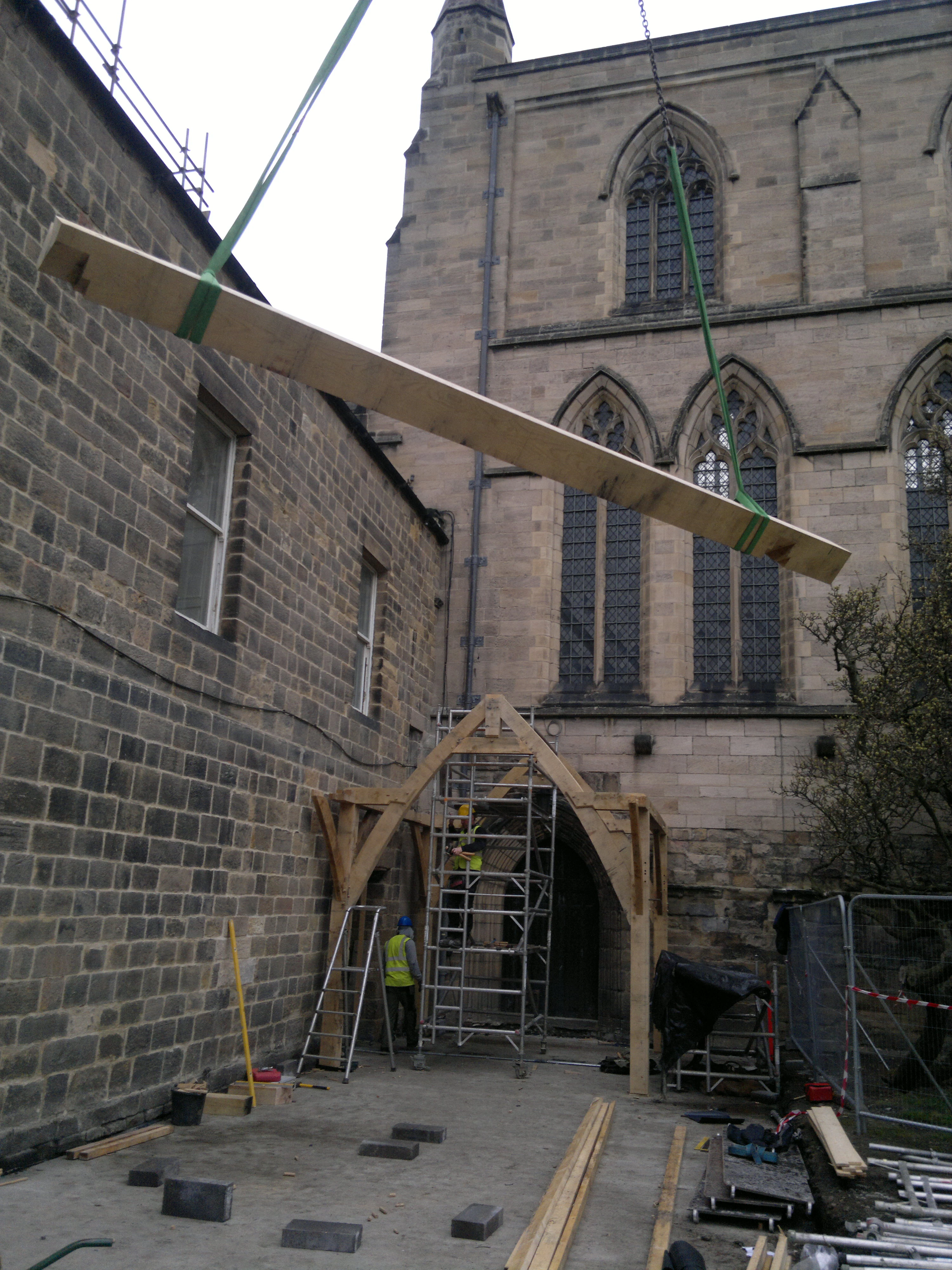 Beam being lifted into position for the oak-framed cloister