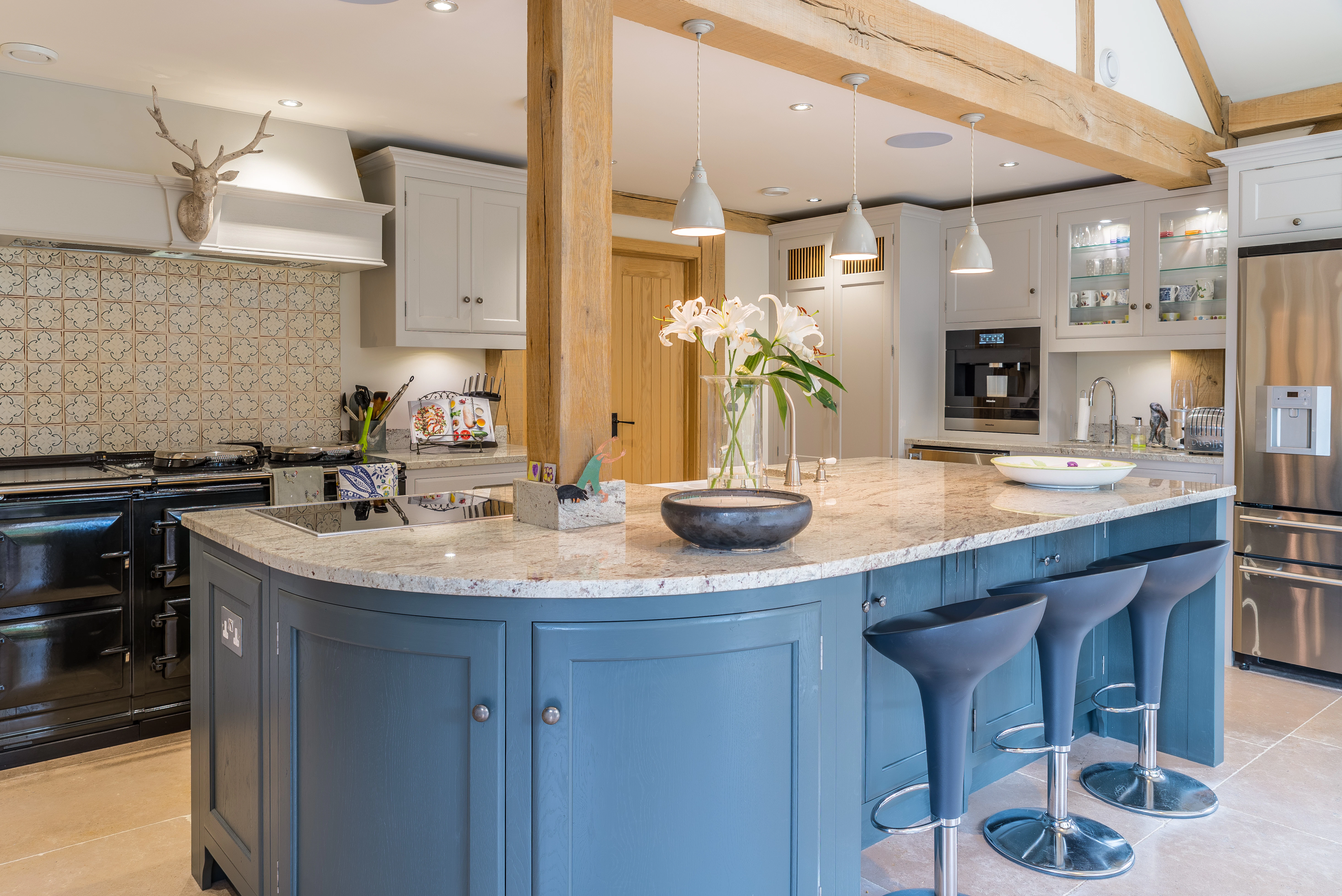 Open-plan oak-framed kitchen and dining room featuring a central curved island