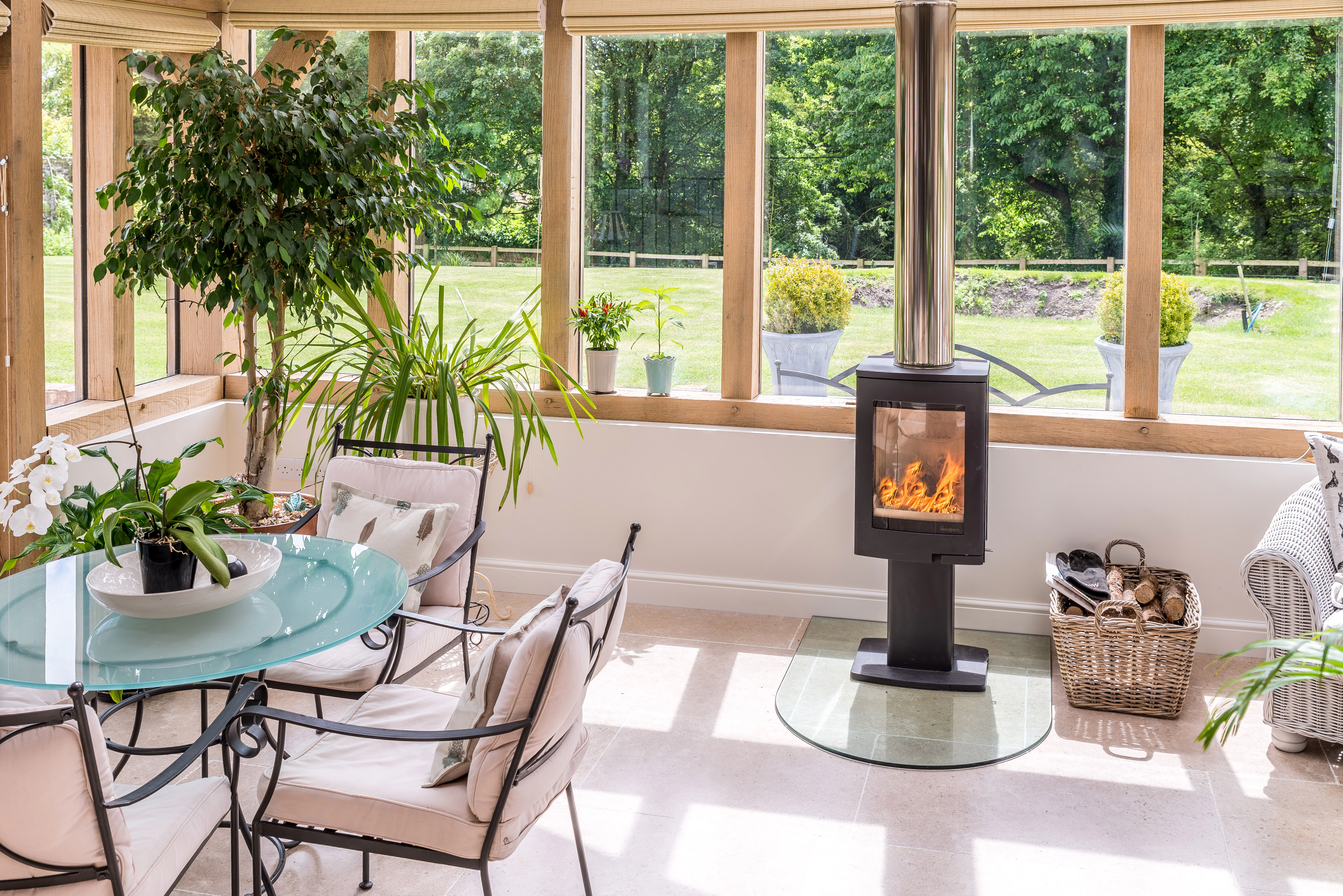 Internal view of an open-plan living space with vaulted ceilings, a central fireplace, and a glazed gable end featuring a direct glazing system