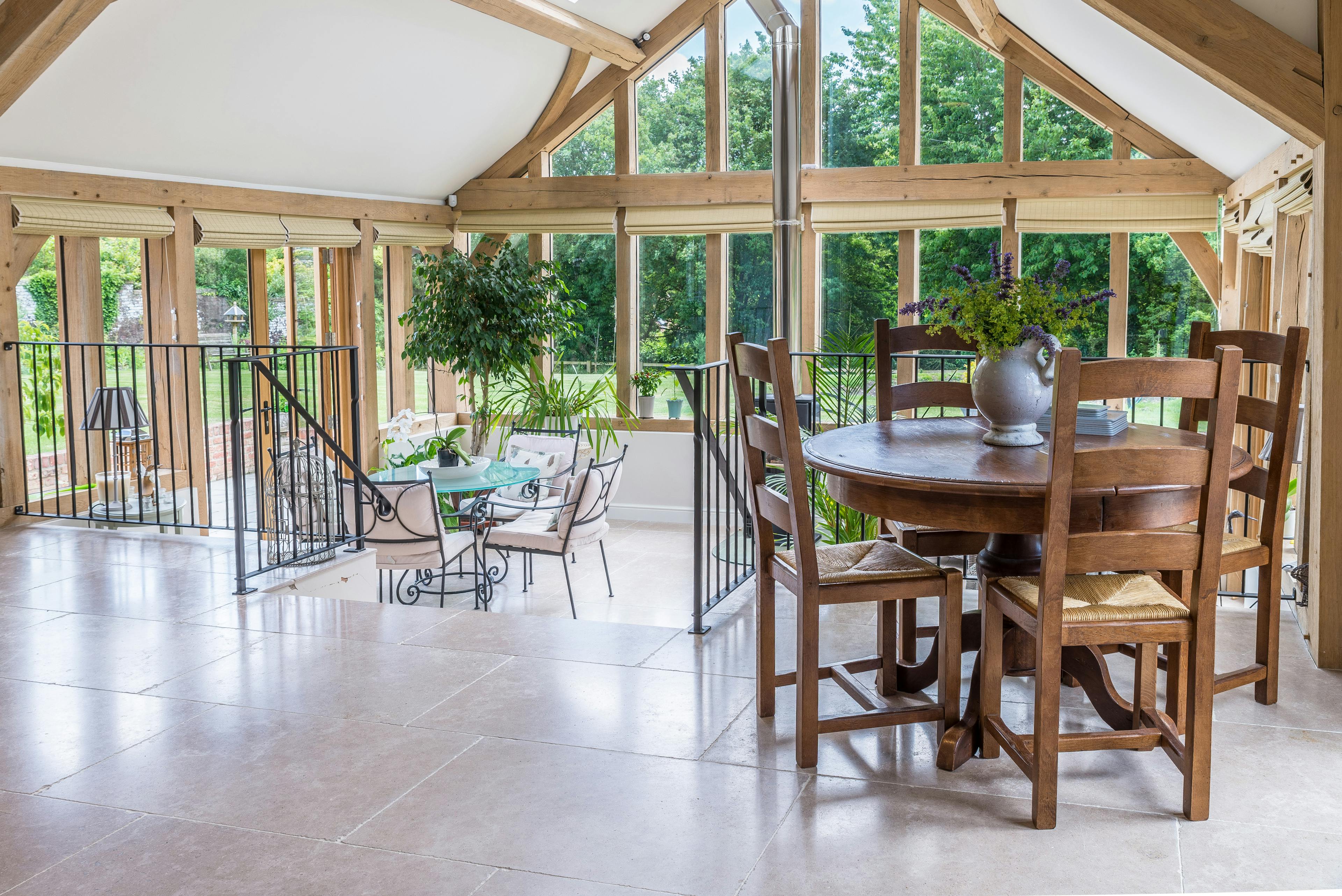 Internal view of a tiered open-plan living space with vaulted ceilings, a central fireplace, and a glazed gable end with a direct glazing system