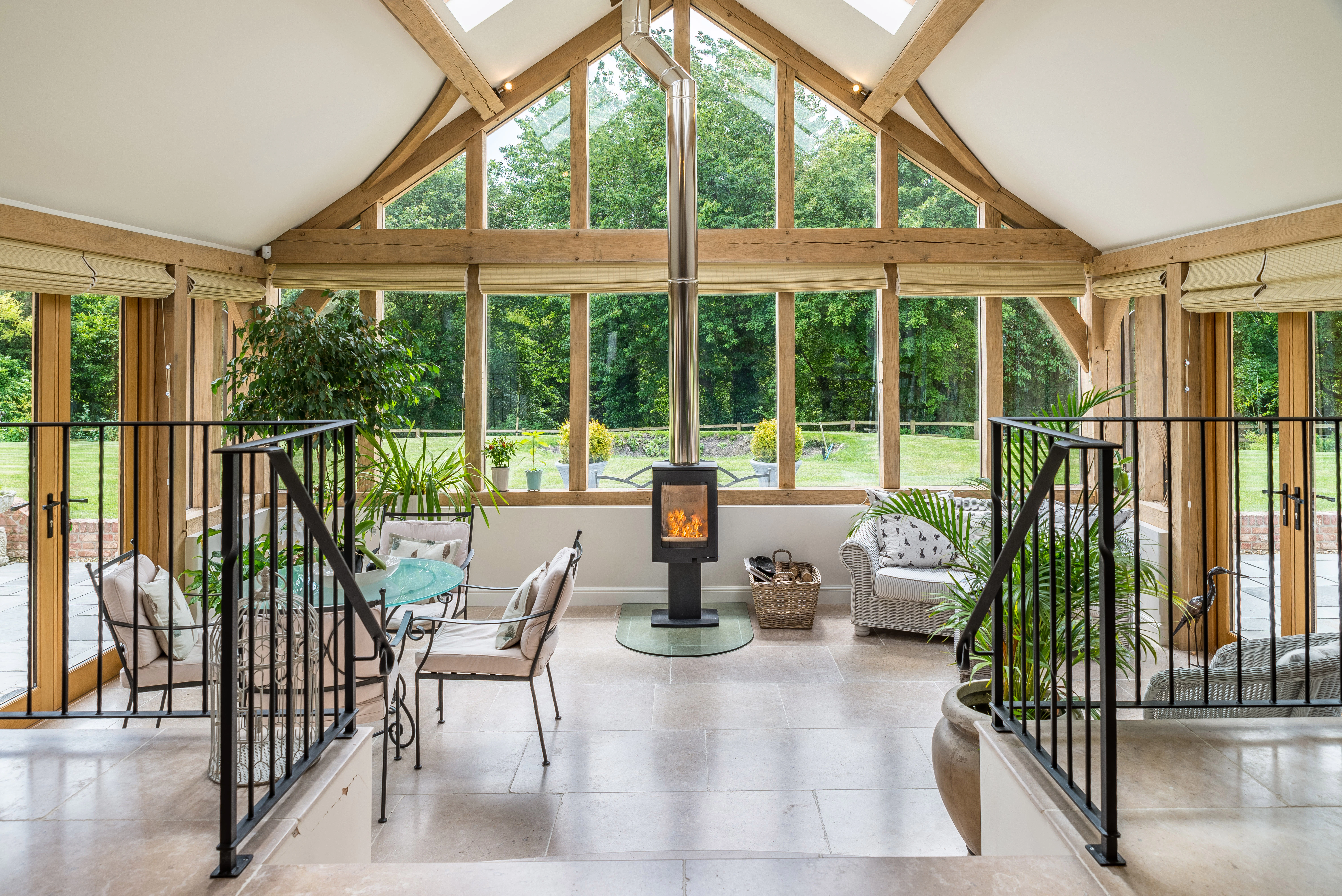 Internal view of a tiered open-plan living space with vaulted ceilings, a central fireplace, and a glazed gable end
